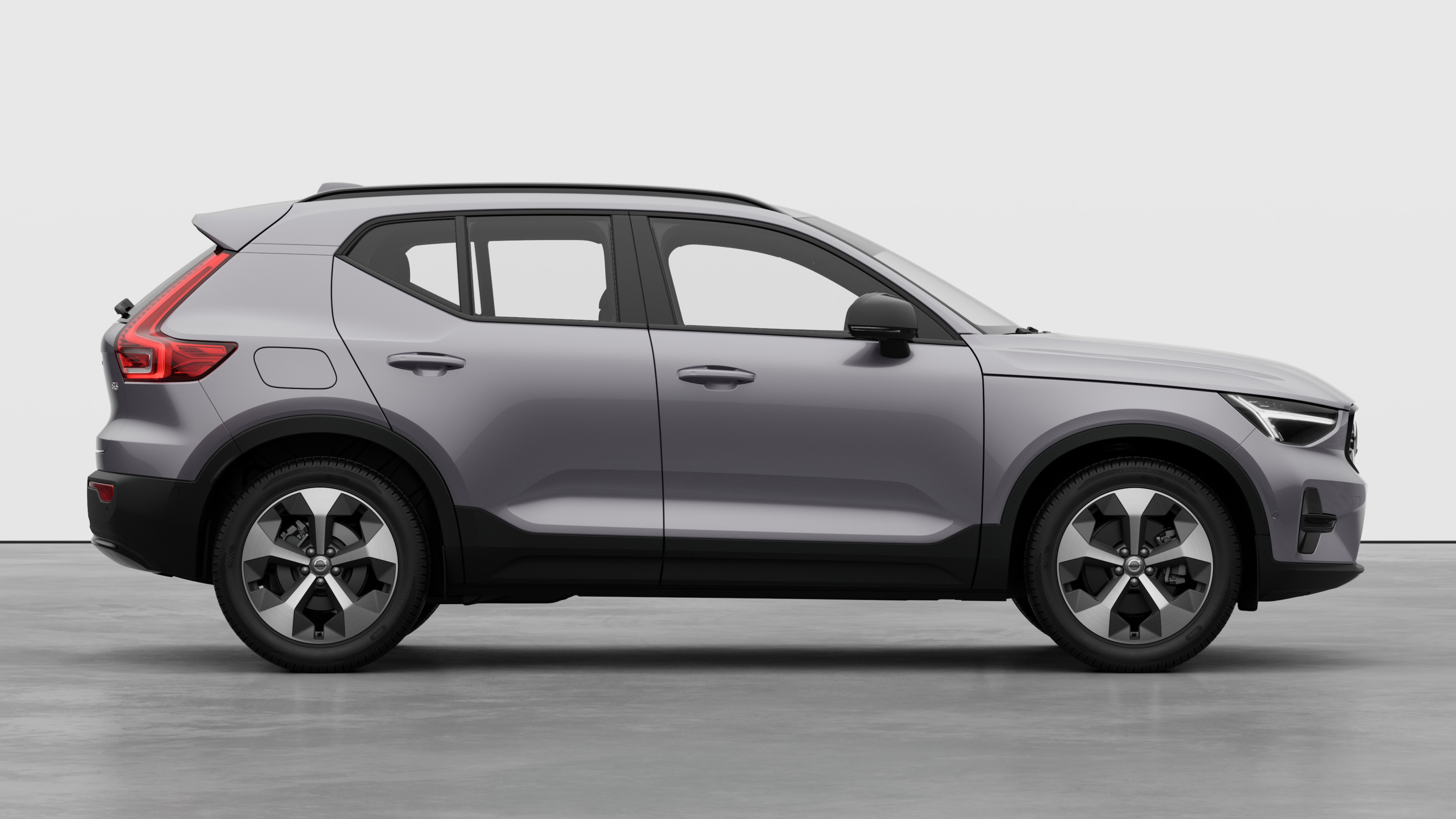 Vista laterale di un'auto Volvo sullo sfondo di uno studio che mostra le portiere chiuse e il design visibile delle ruote.