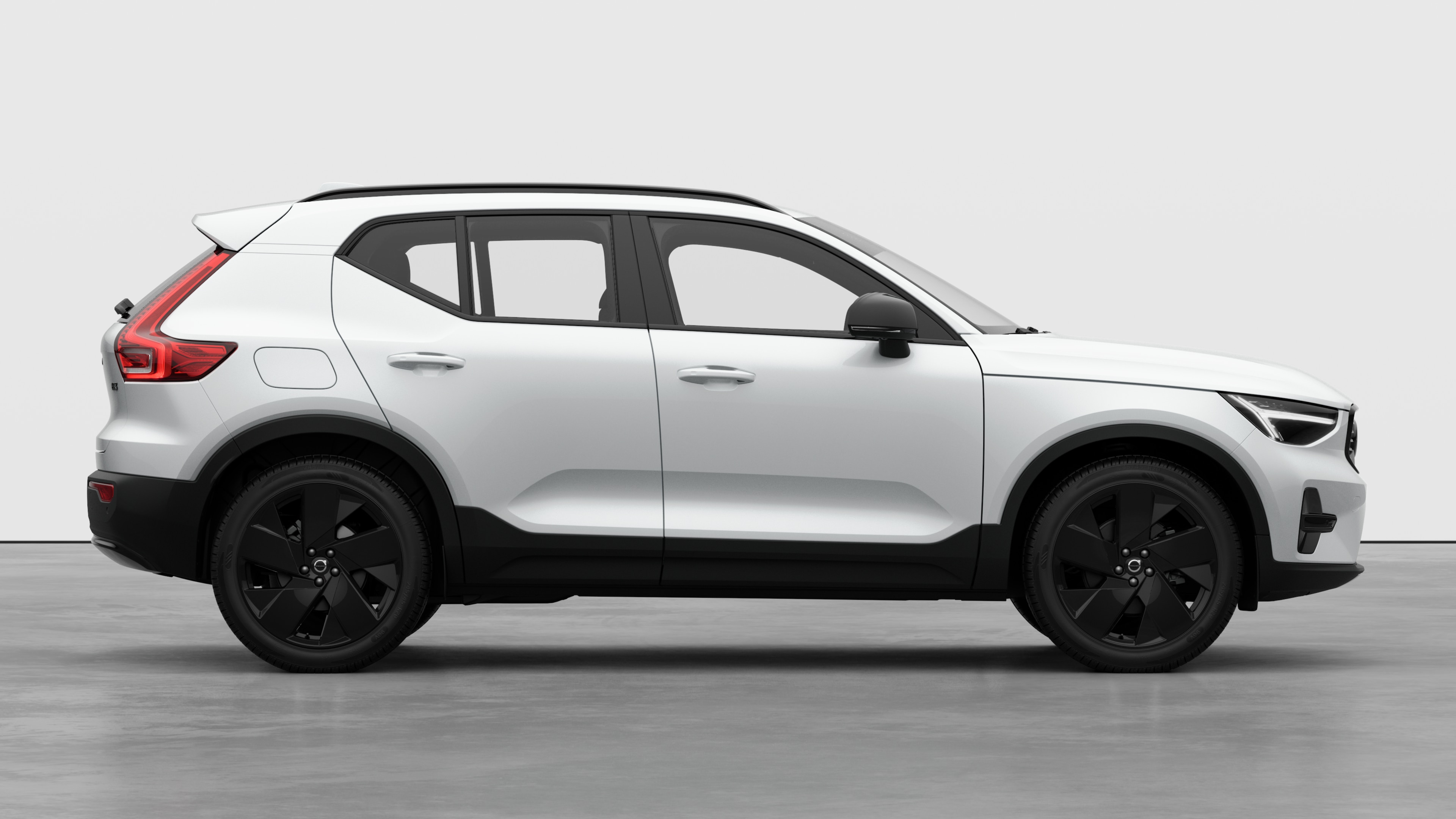 Seitenansicht eines Volvo Fahrzeugs auf einem schlichten Studiohintergrund mit geschlossenen Türen und sichtbarem Raddesign.