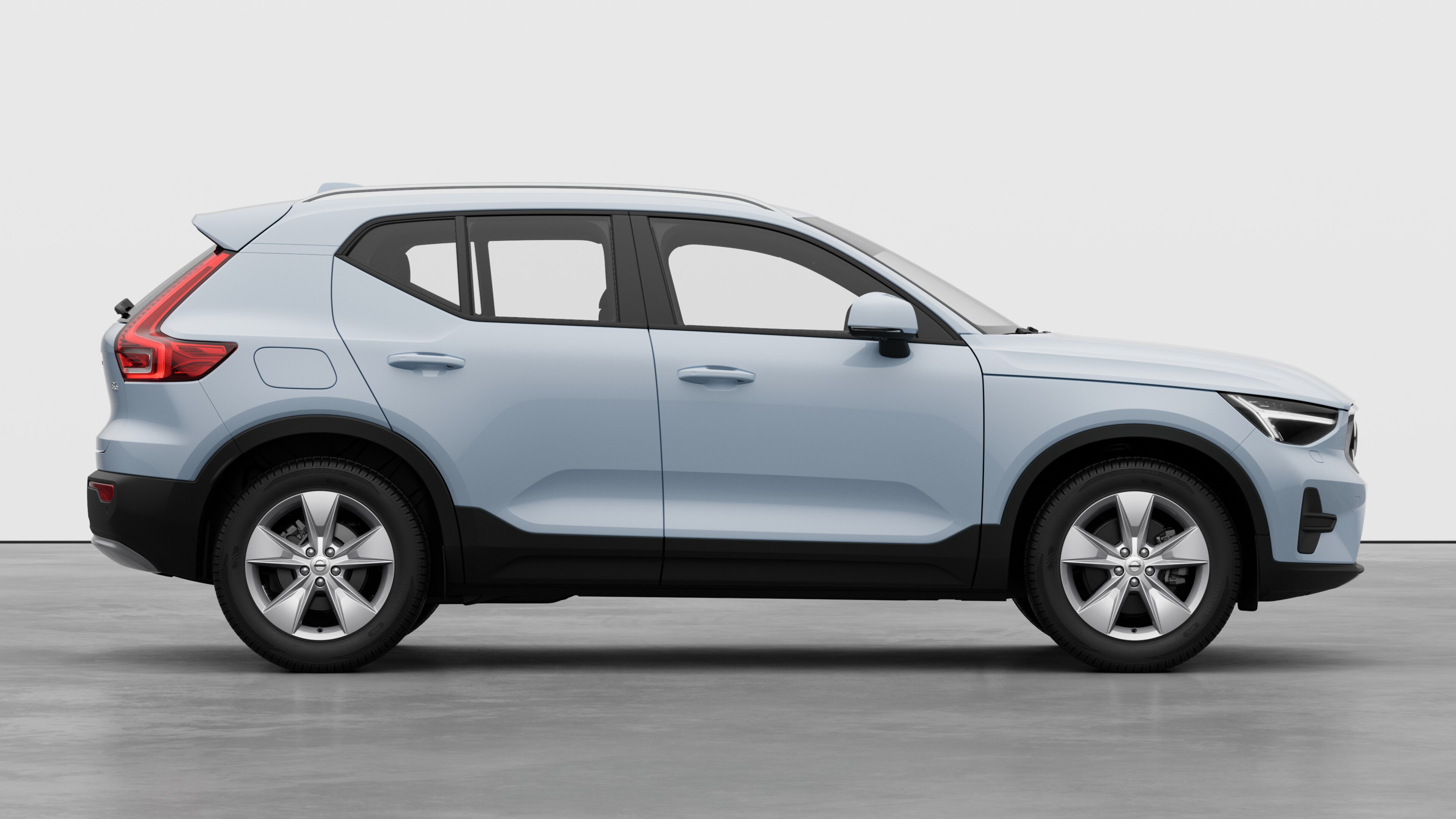 Sidovy från Volvo-bilen på en vanlig studiobakgrund som visar stängda dörrar och synlig fälgdesign.