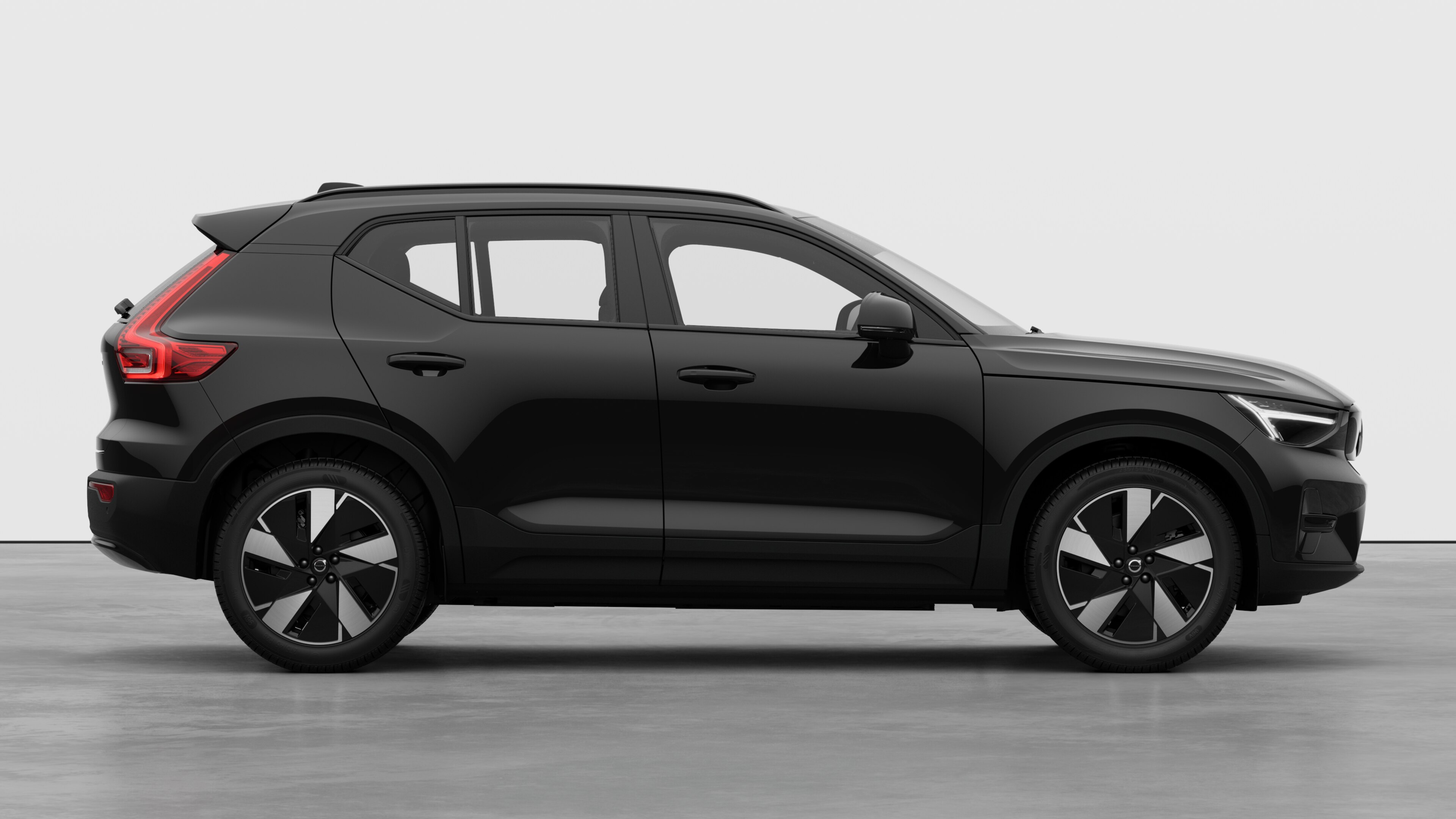 Volvo car side view on plain studio background displaying closed doors and visible wheel design.