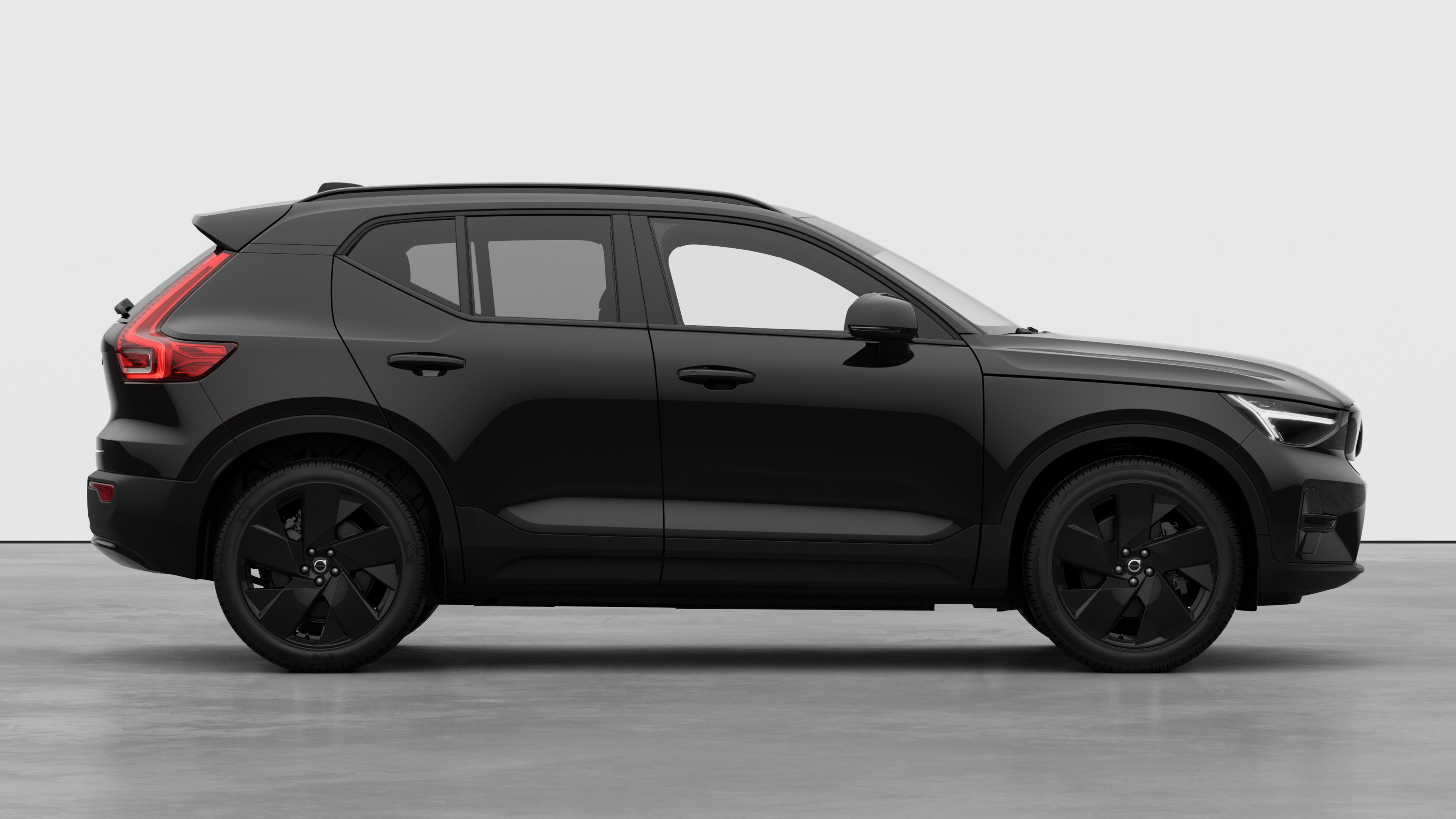 Vue latérale d’une Volvo sur fond de studio montrant les portes fermées et le design des roues visible.