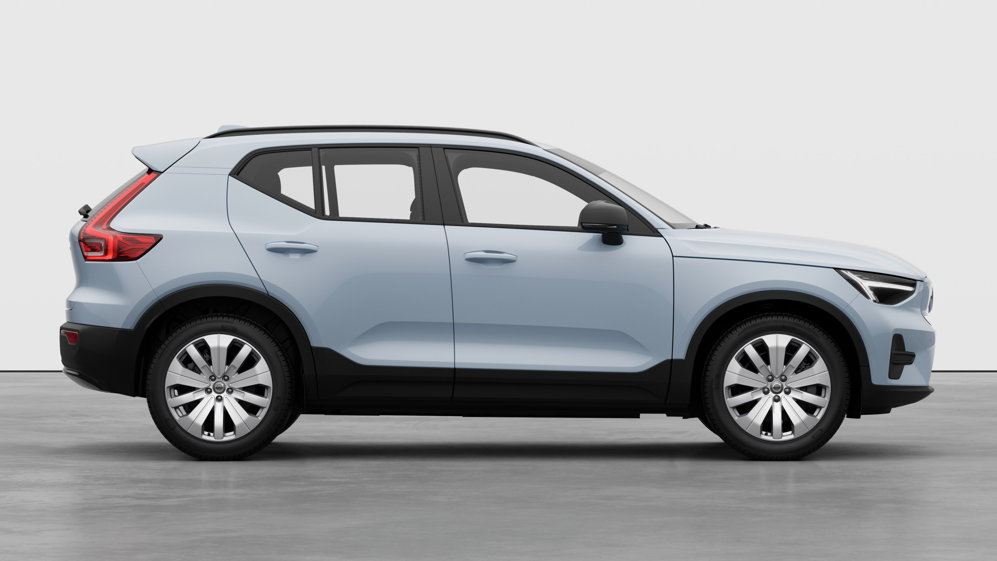 Vista laterale di un'auto Volvo sullo sfondo di uno studio che mostra le portiere chiuse e il design visibile delle ruote.