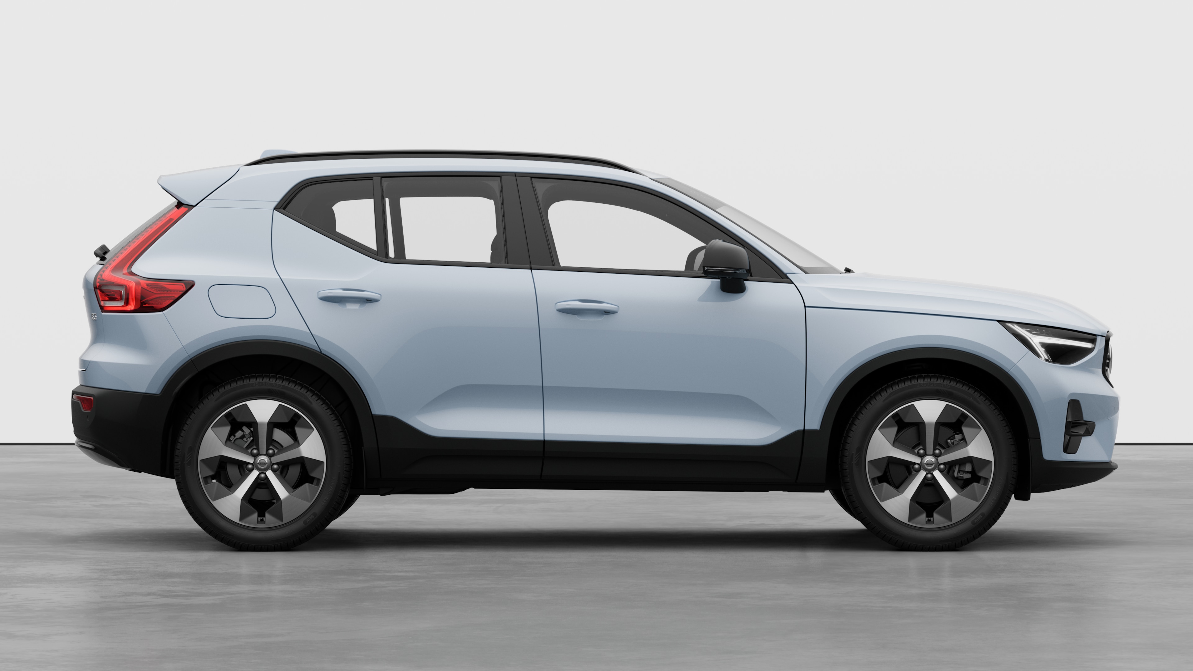 Volvo car side view on plain studio background displaying closed doors and visible wheel design.