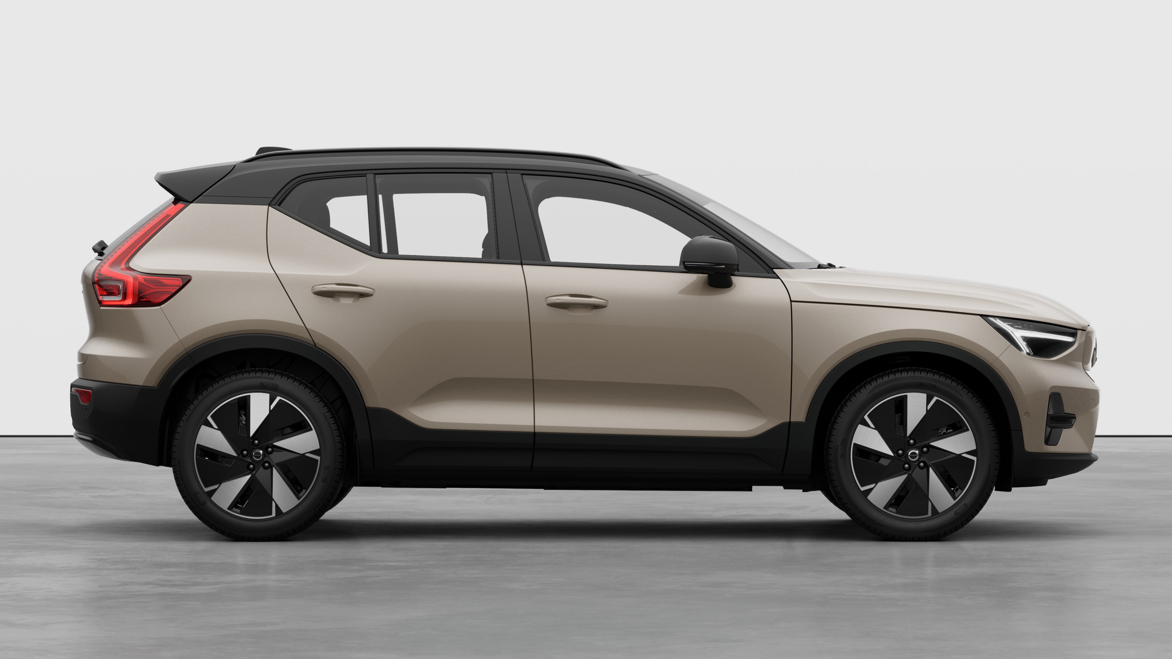 Vista laterale di un'auto Volvo sullo sfondo di uno studio che mostra le portiere chiuse e il design visibile delle ruote.