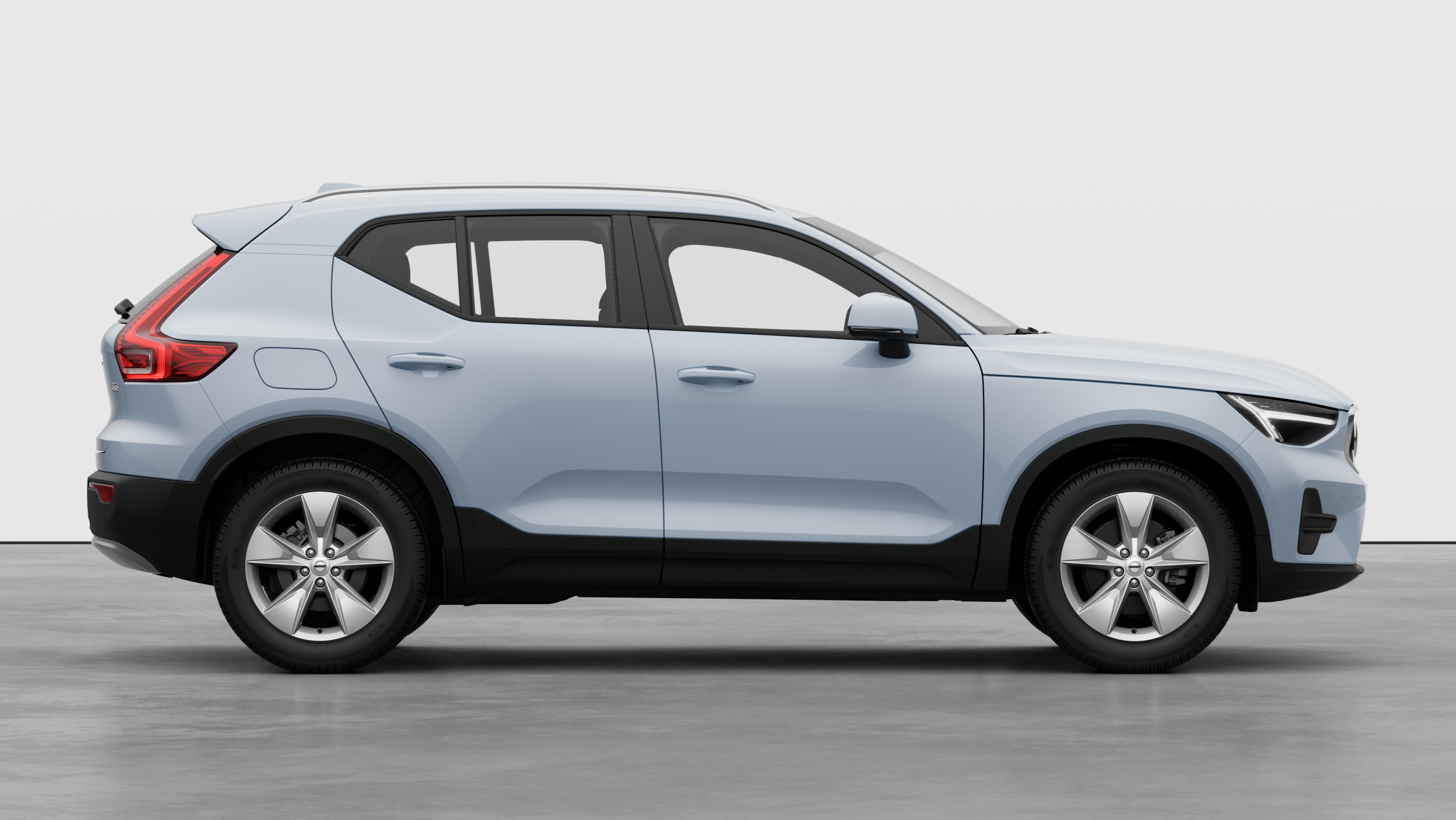 Bočni pogled automobila Volvo na običnoj pozadini studija s prikazom zatvorenih vrata i vidljivim dizajnom kotača.