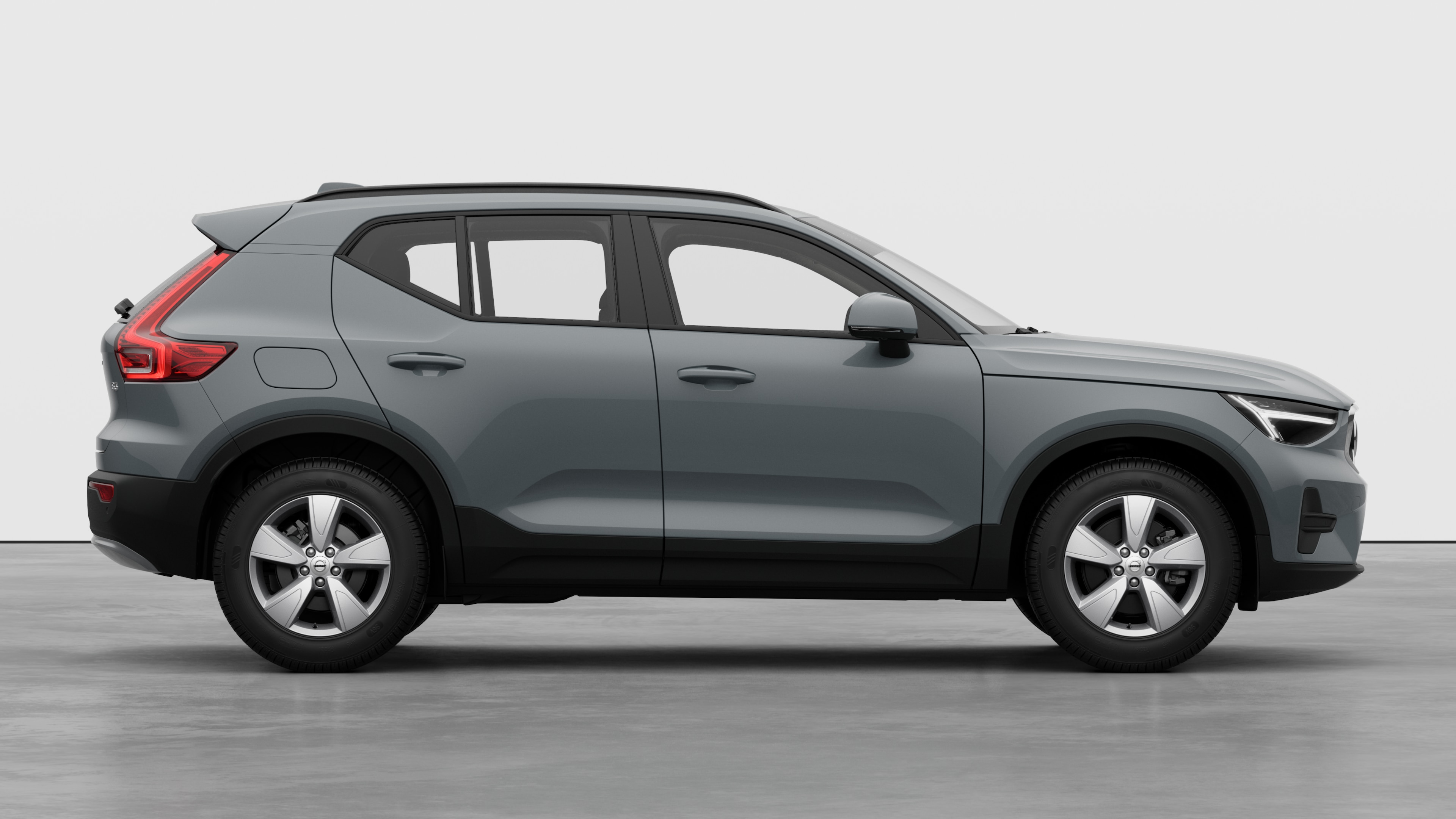 Zijaanzicht van een Volvo op een eenvoudige studioachtergrond met gesloten deuren en zichtbaar wielontwerp.