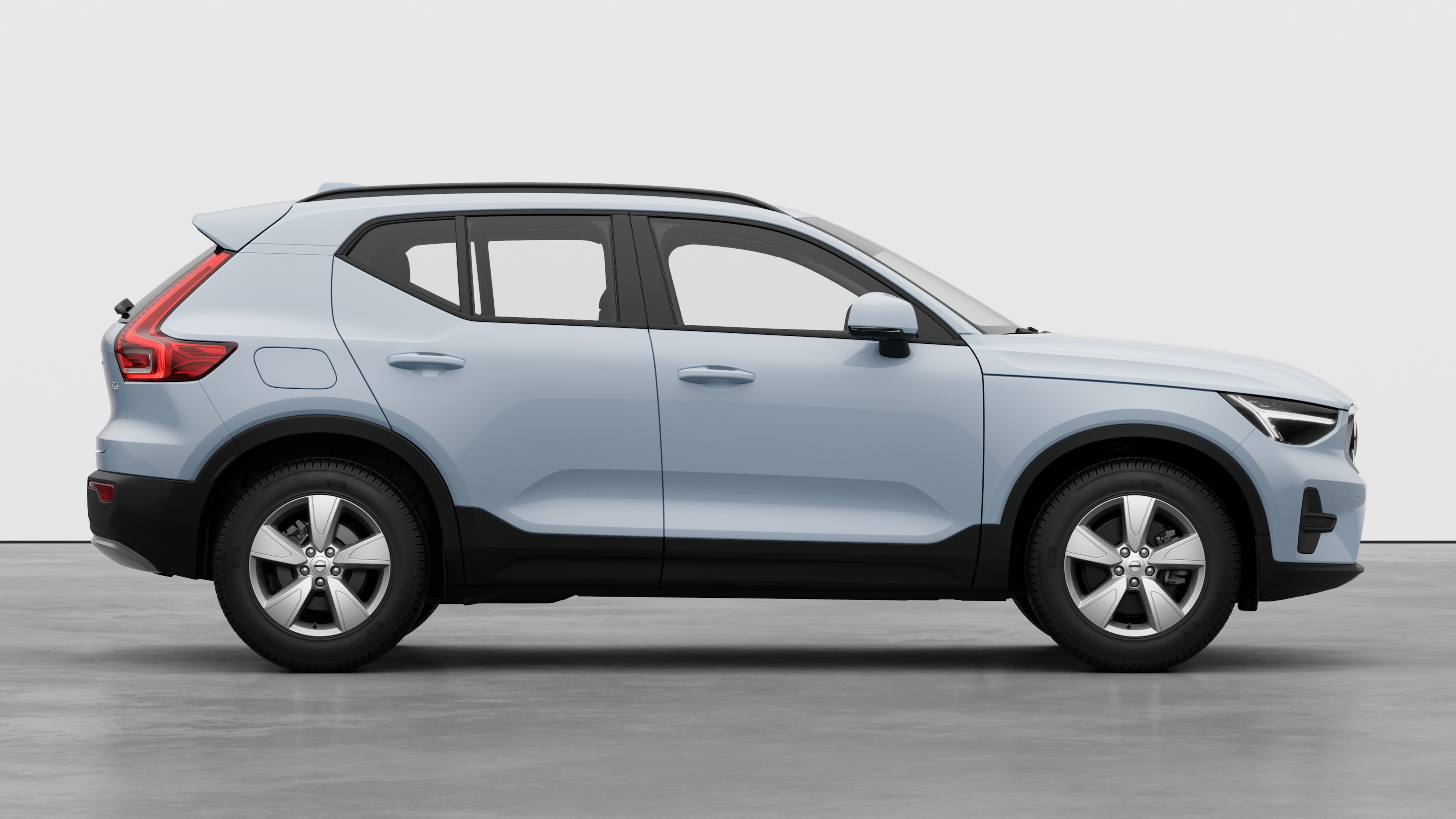 Seitenansicht eines Volvo Fahrzeugs auf einem schlichten Studiohintergrund mit geschlossenen Türen und sichtbarem Raddesign.