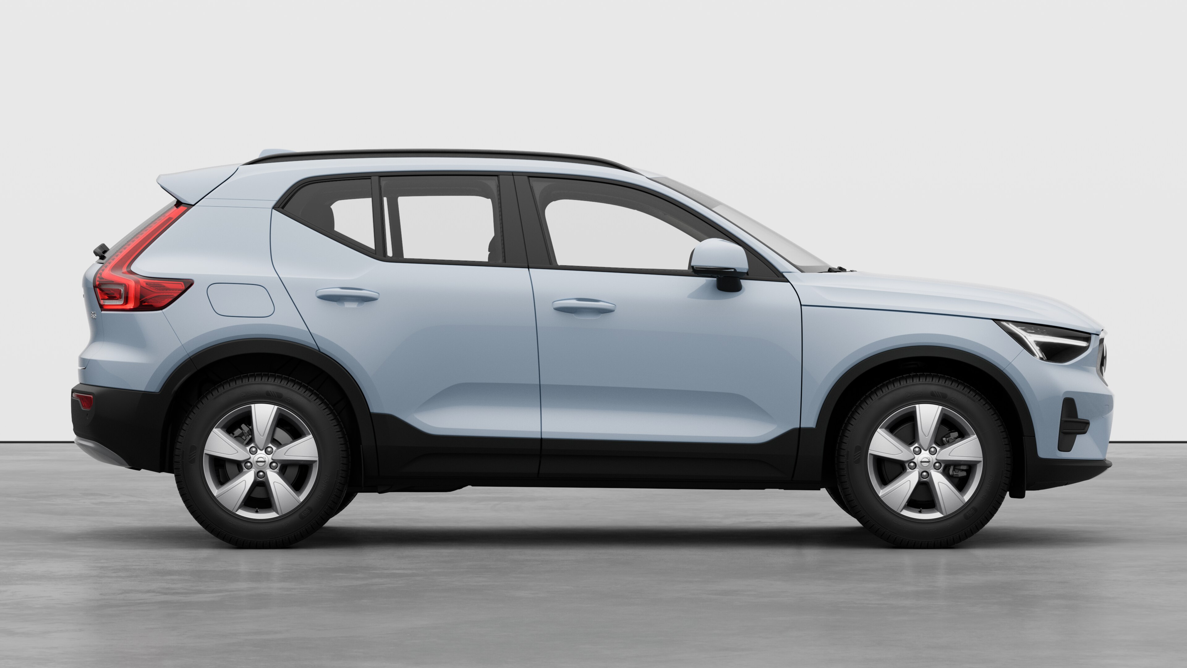 Zijaanzicht van de Volvo-auto op een effen studioachtergrond met gesloten deuren en een zichtbaar wielontwerp.