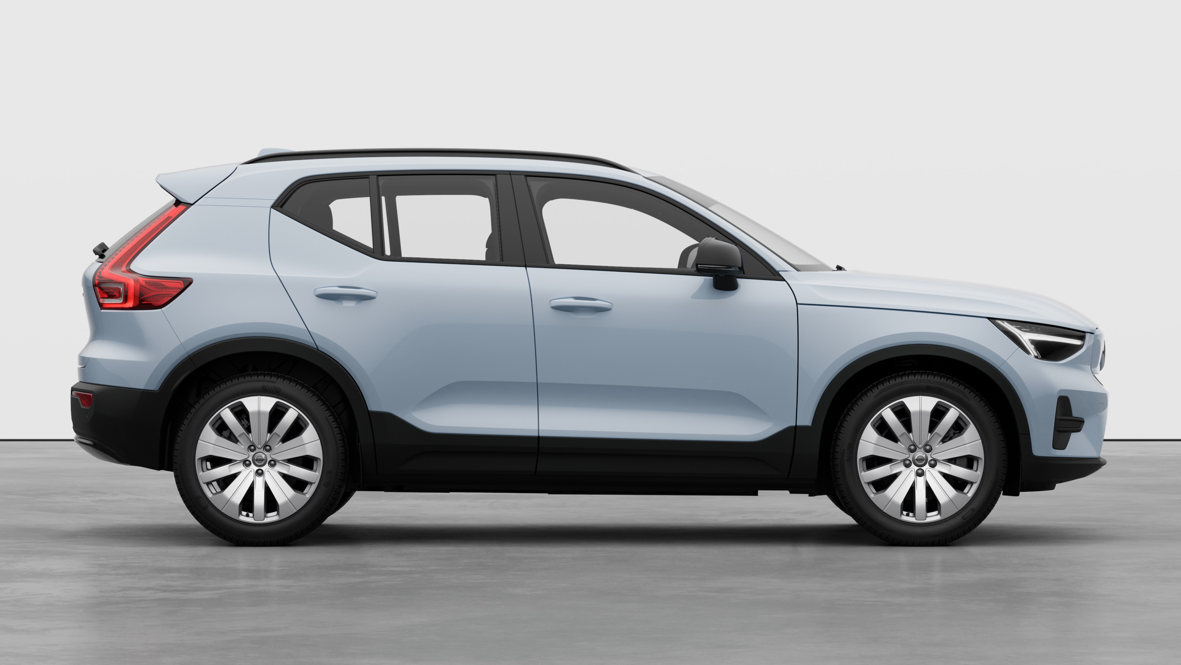 Volvo car side view on plain studio background displaying closed doors and visible wheel design.