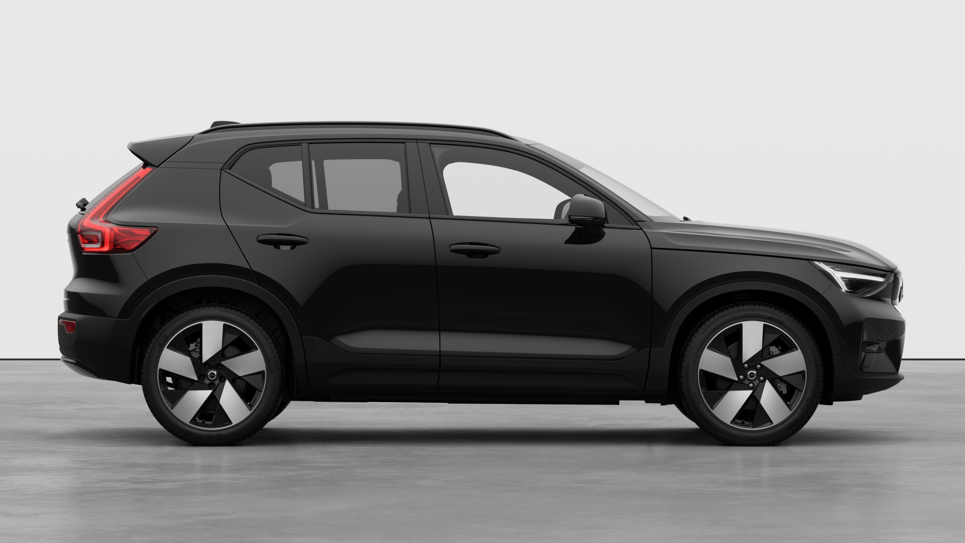 Volvo car side view on plain studio background displaying closed doors and visible wheel design.