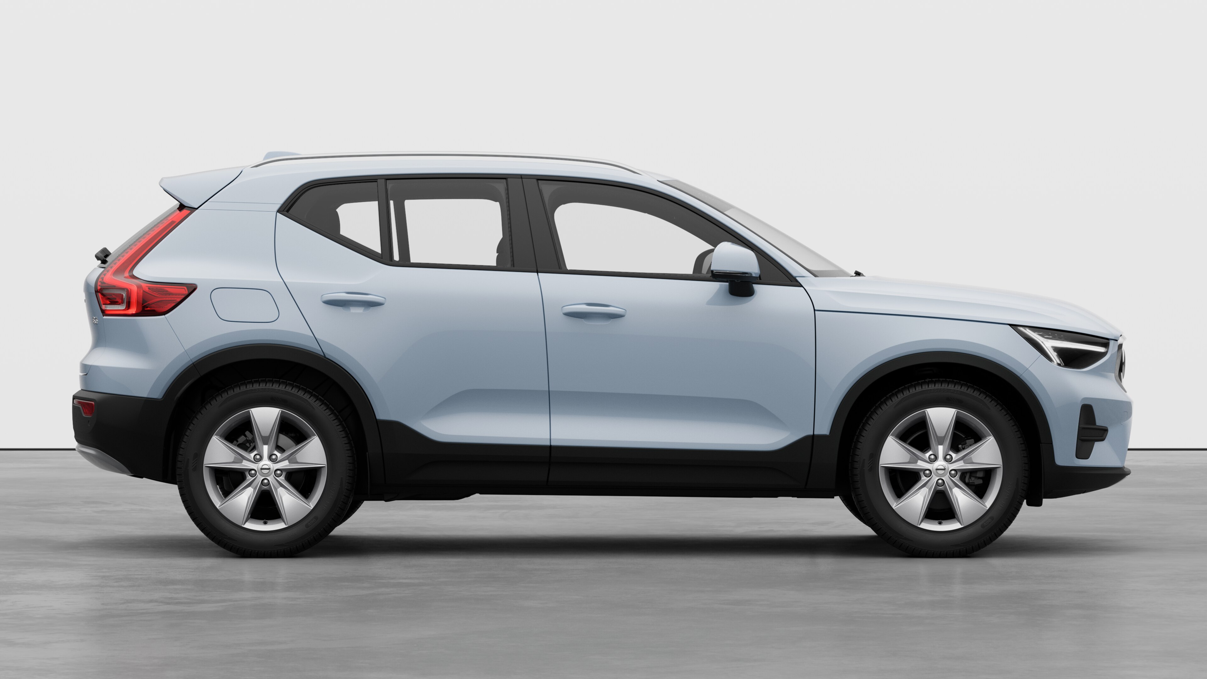 Volvo car side view on plain studio background displaying closed doors and visible wheel design.