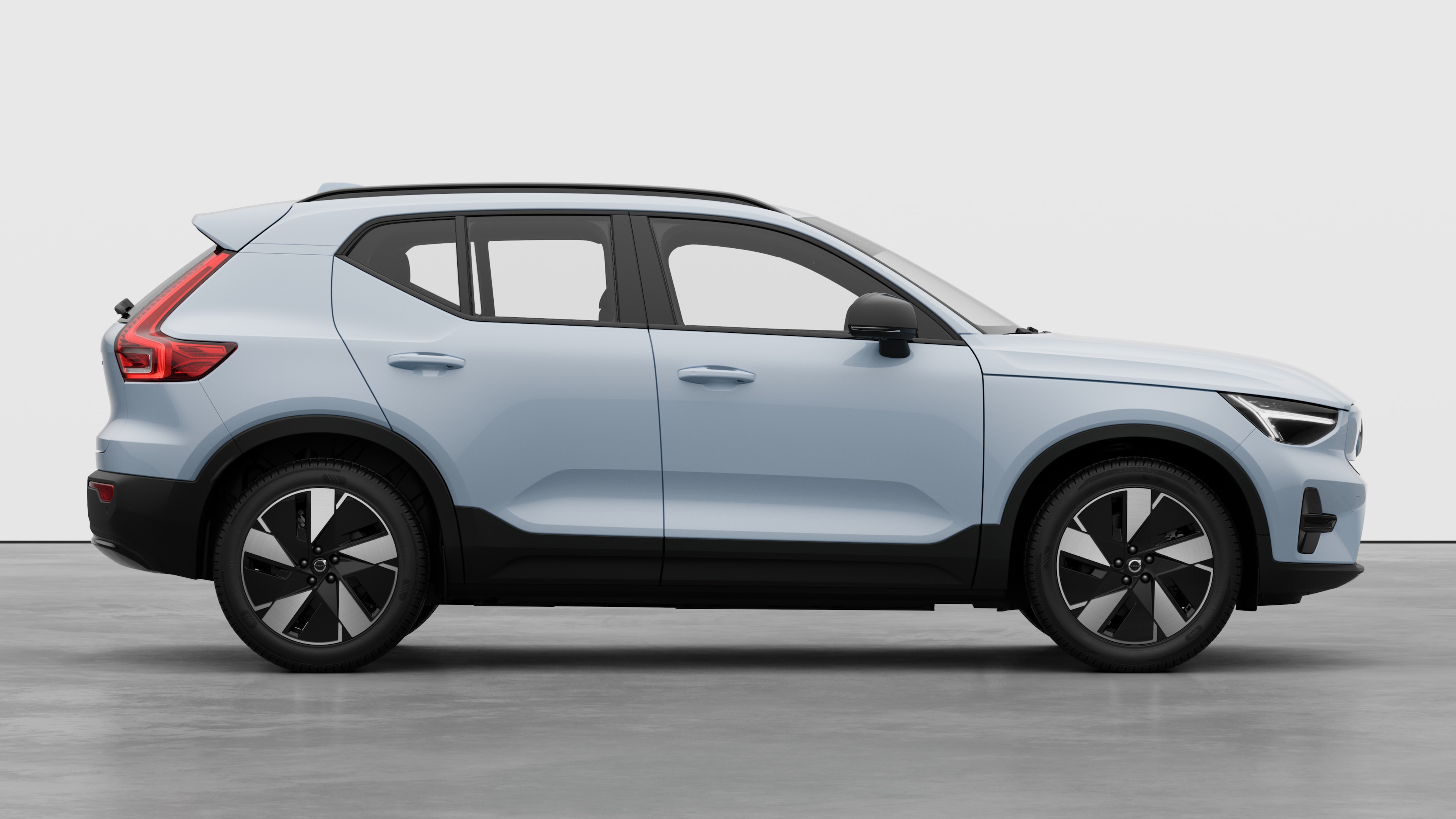 Vedere laterală a mașinii Volvo pe fundal simplu de studio, care afișează ușile închise și designul vizibil al roților.