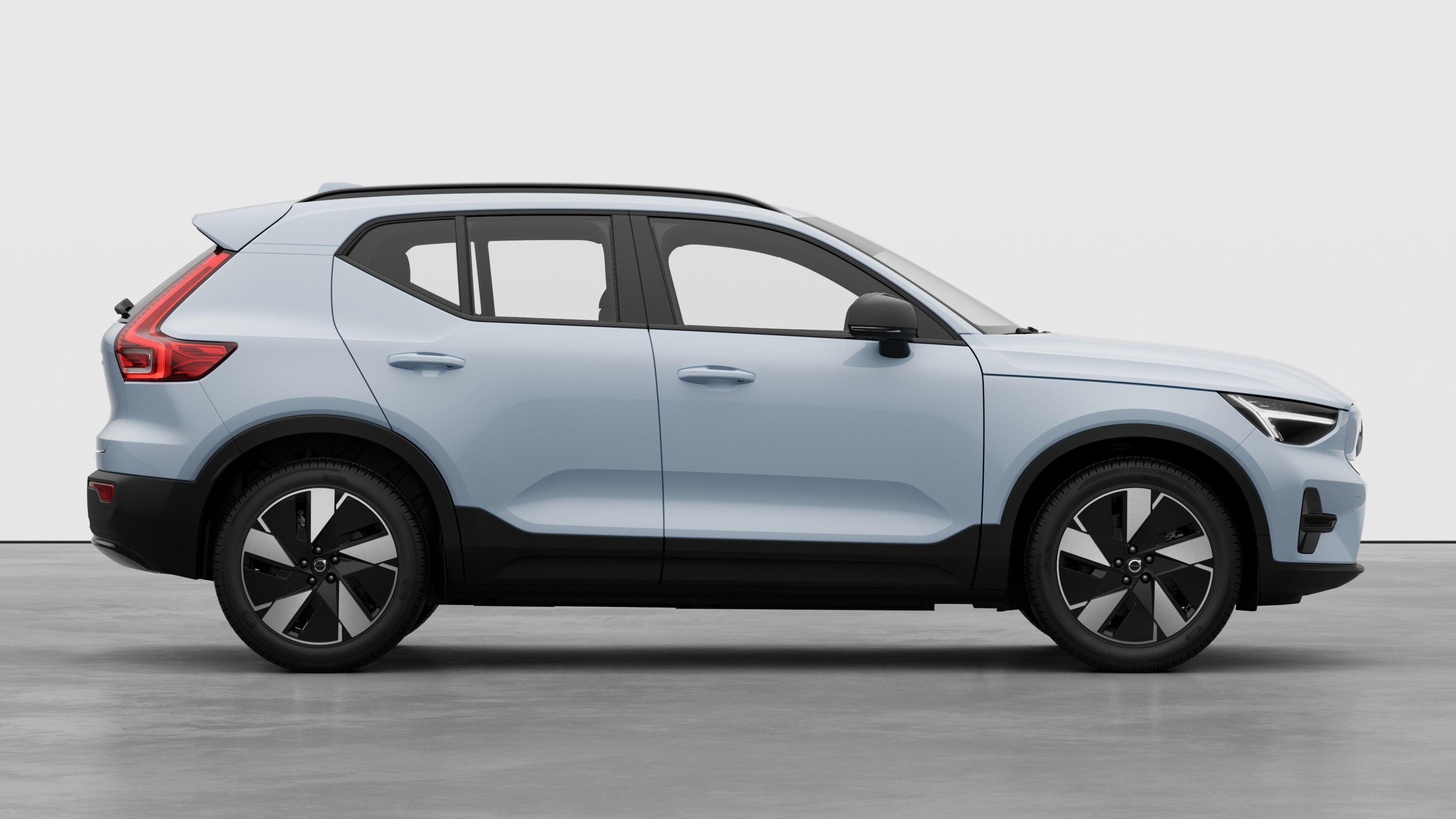 "Volvo" automobilio vaizdas iš šono paprastame studijos fone, rodomos uždarytos durys ir matomas rato dizainas.