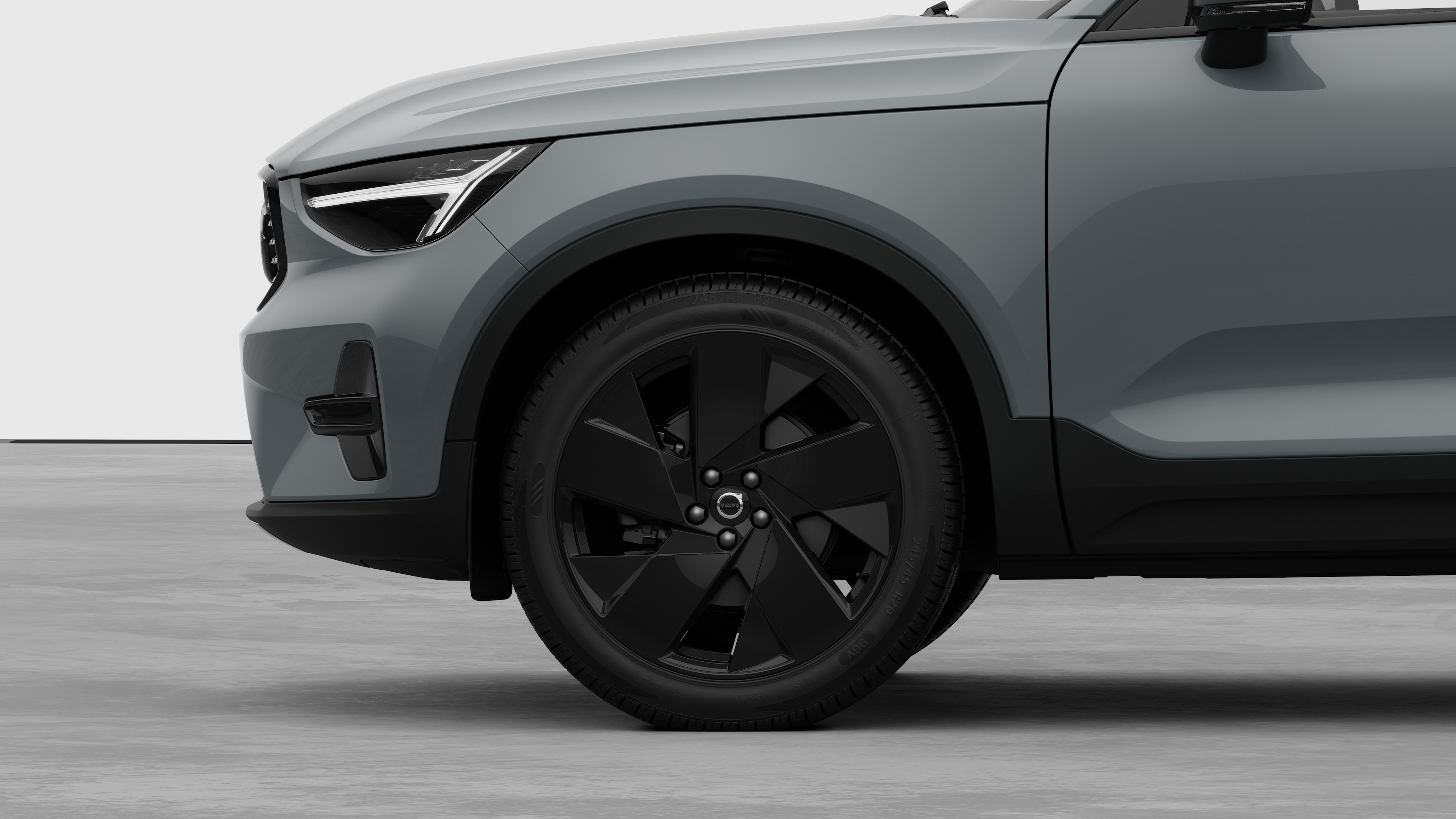 Seitenansicht eines Volvo Fahrzeugs mit Fokus auf Vorderrad und Kotflügel vor einem schlichten Studiohintergrund.