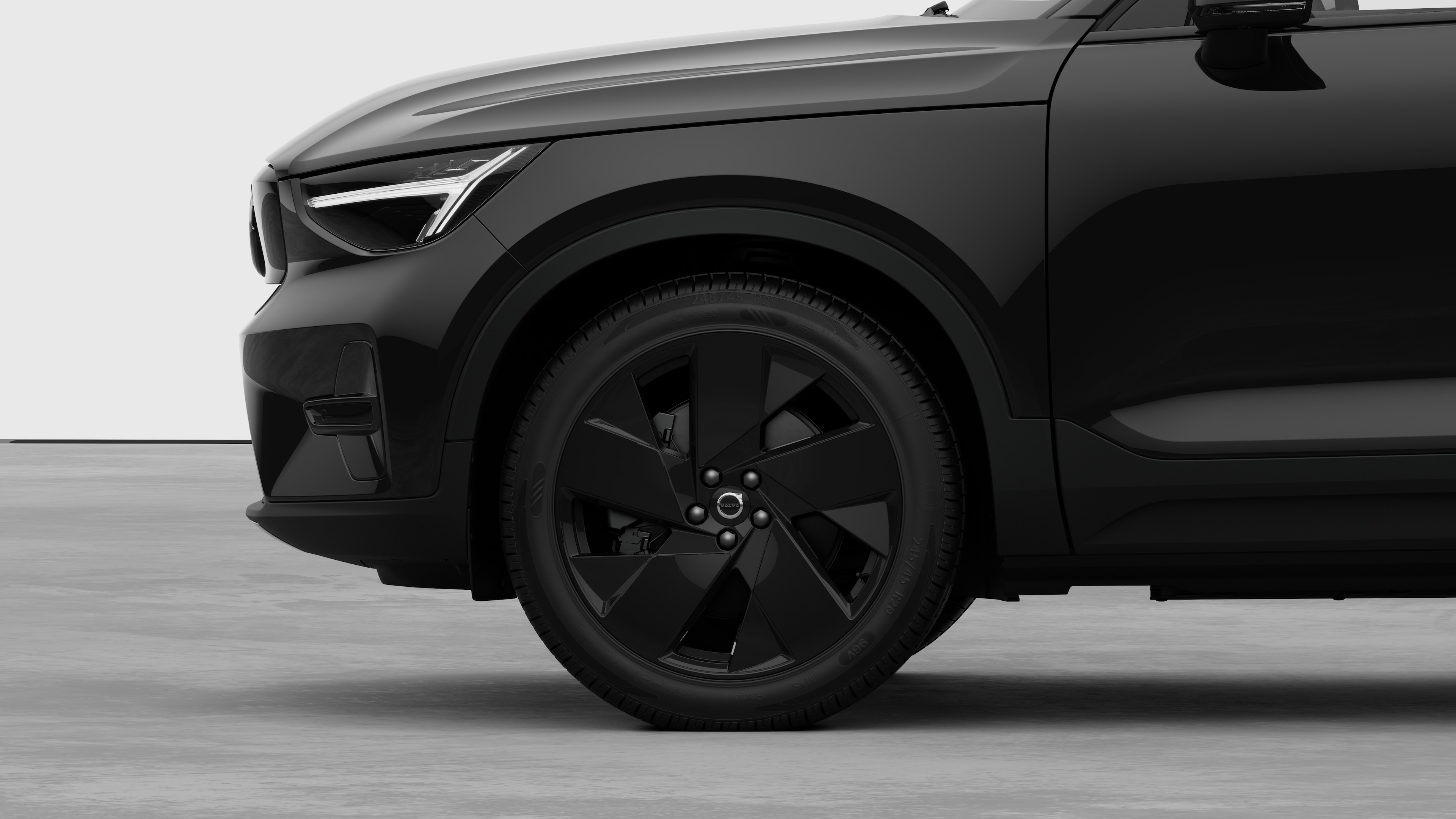 Vue latérale extérieure de la Volvo se concentrant sur la roue avant et l’aile, sur un fond de studio uni.