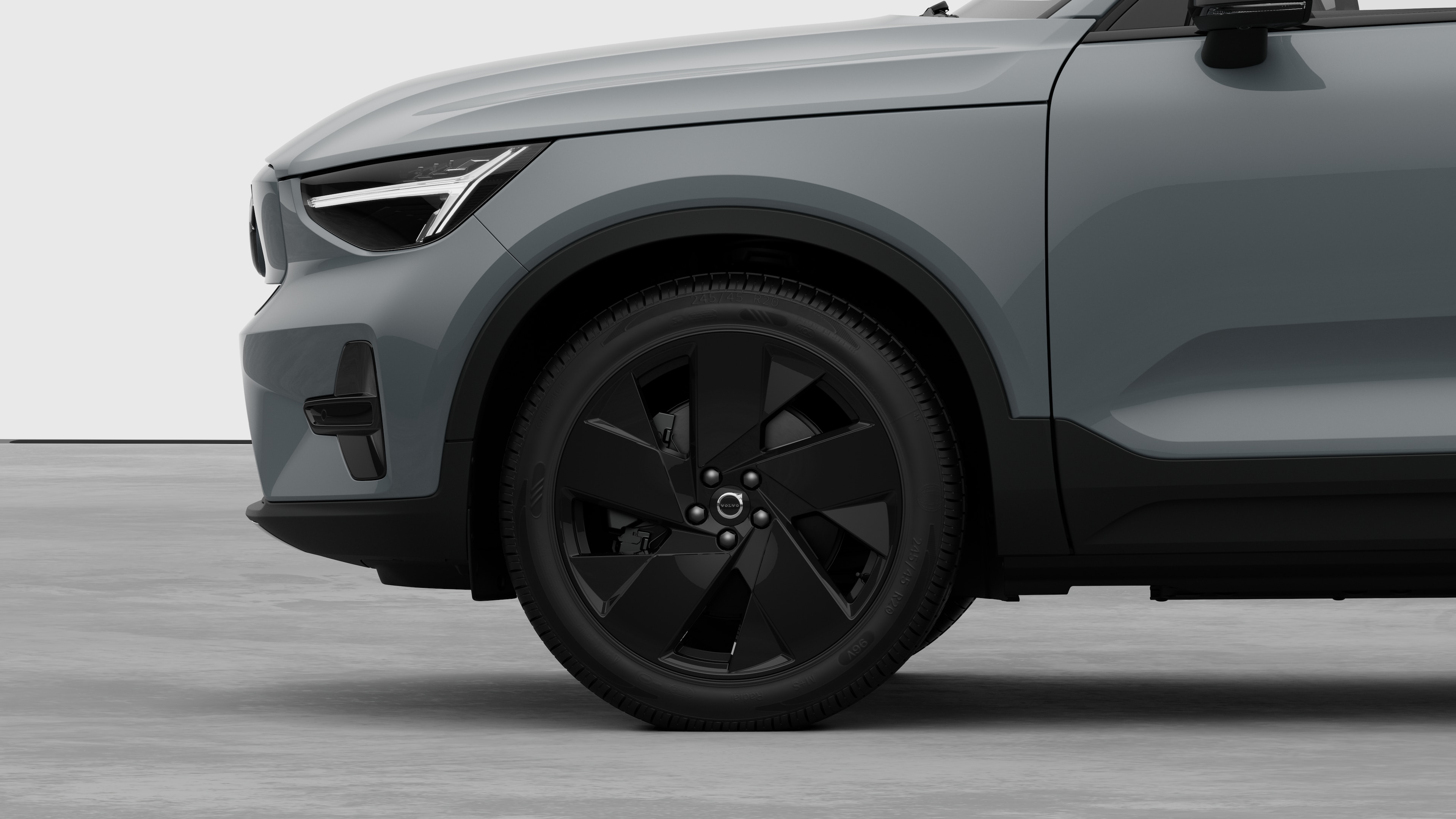 Seitenansicht eines Volvo Fahrzeugs mit Fokus auf Vorderrad und Kotflügel vor einem schlichten Studiohintergrund.