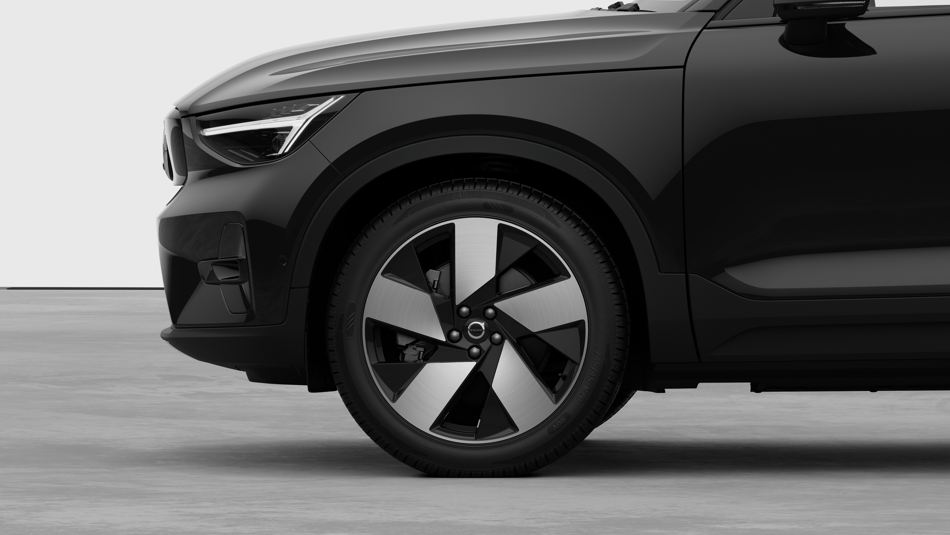 Volvo car exterior side view focusing on the front wheel and fender, set against a plain studio background.