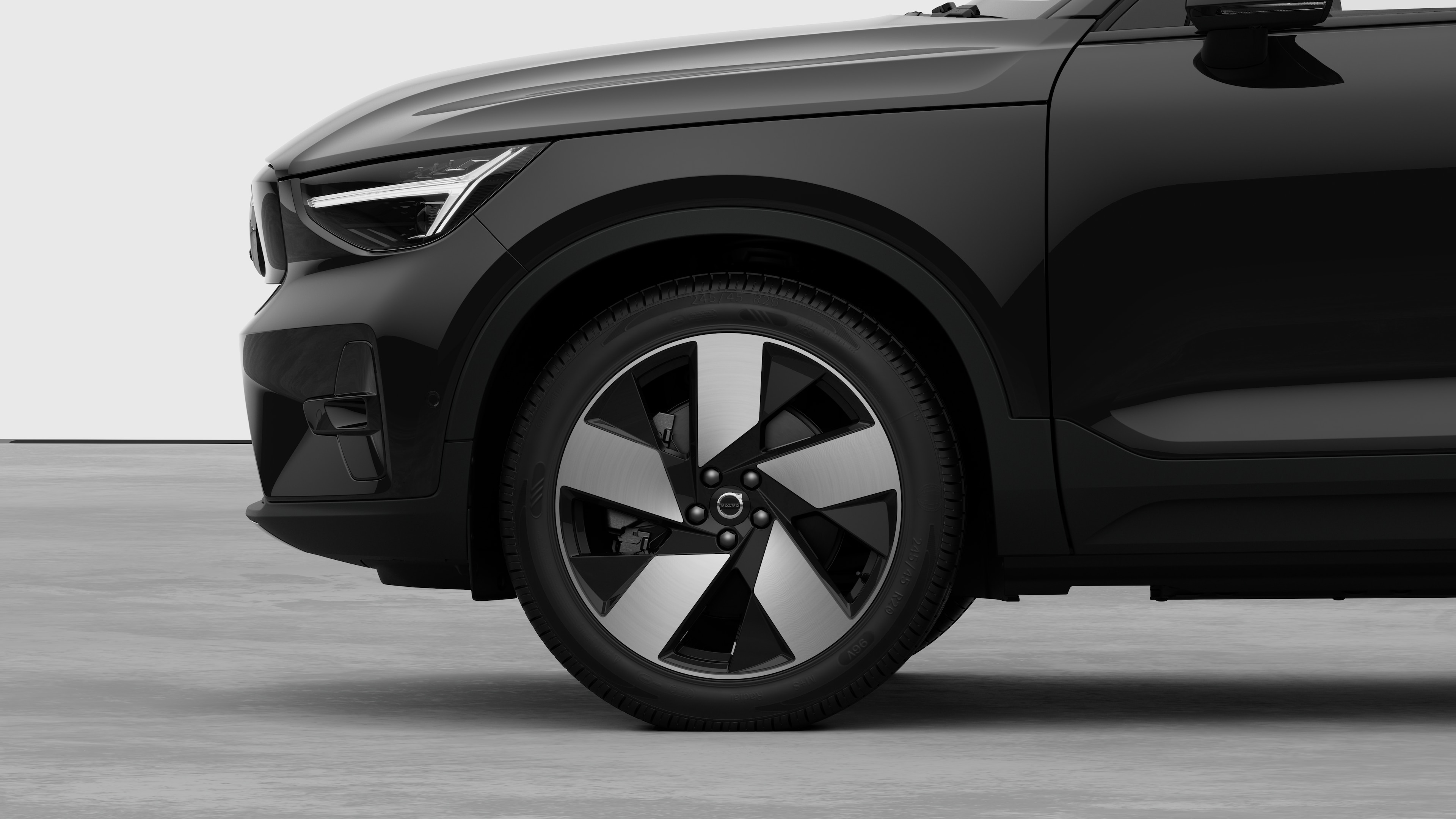 Volvo car exterior side view focusing on the front wheel and fender, set against a plain studio background.