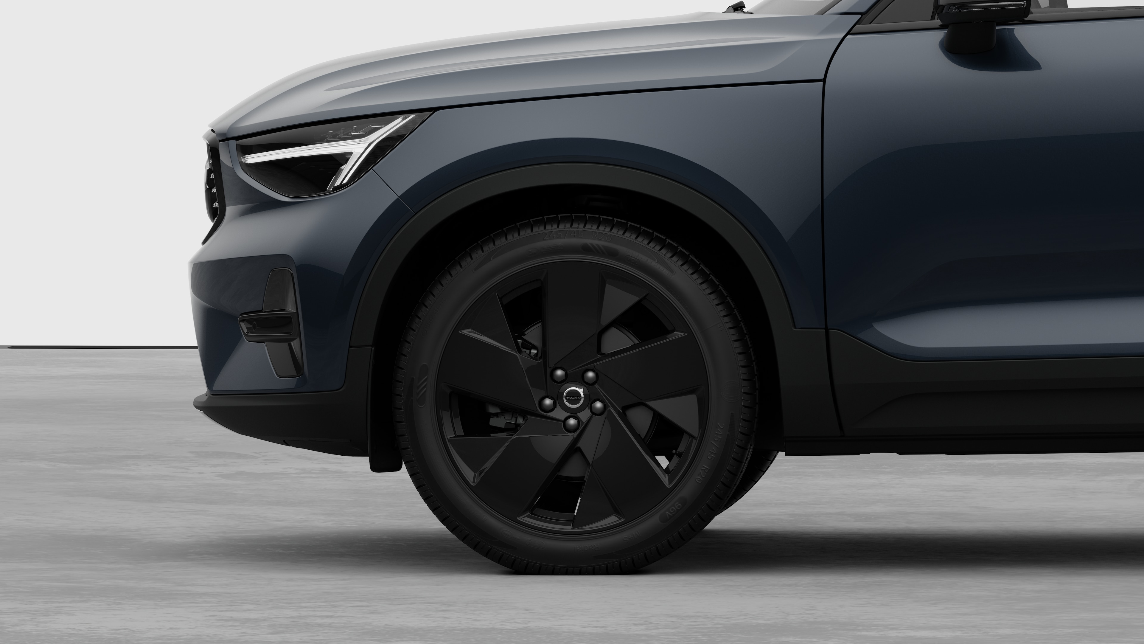 Seitenansicht eines Volvo Fahrzeugs mit Fokus auf Vorderrad und Kotflügel vor einem schlichten Studiohintergrund.