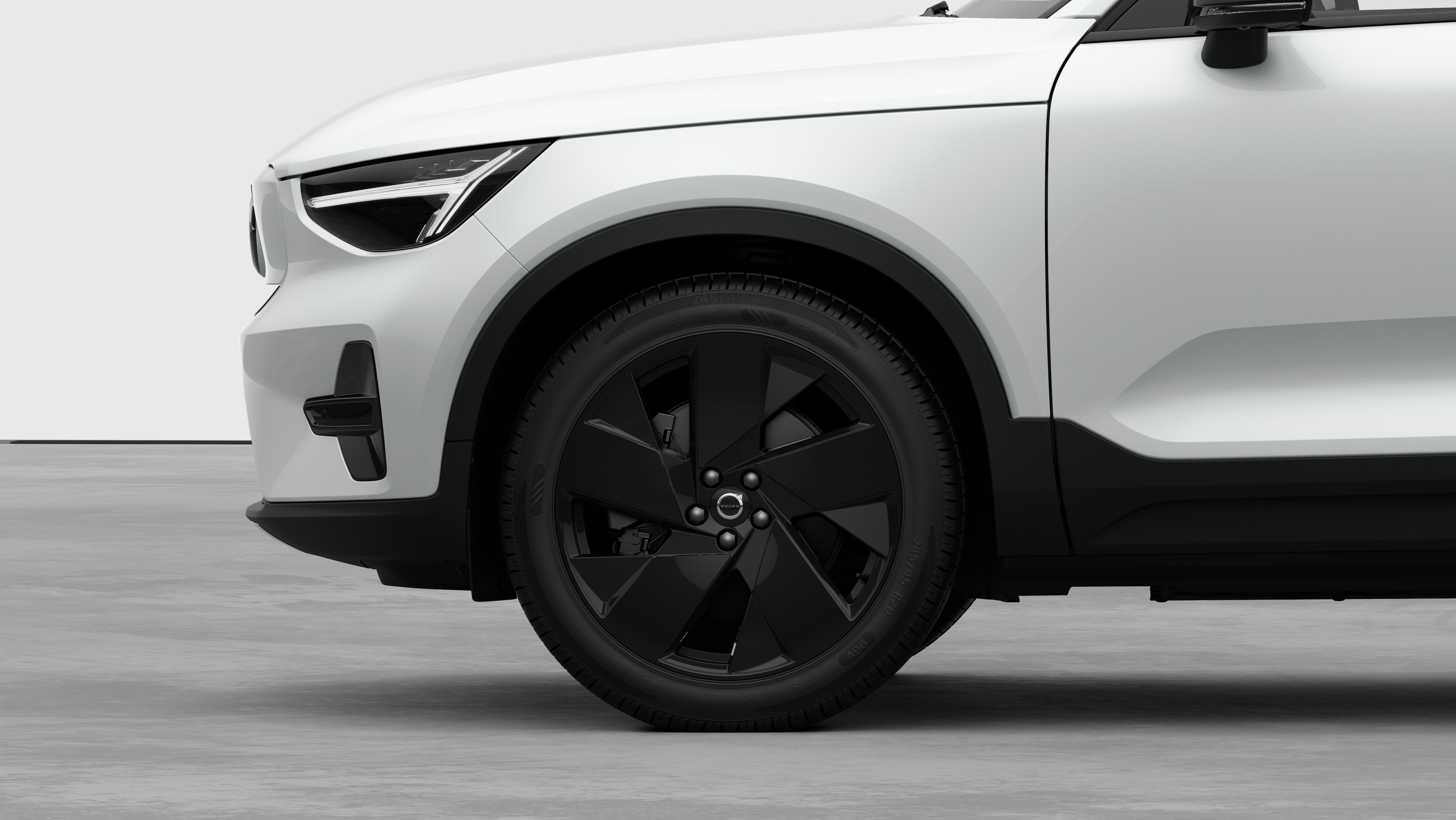 Seitenansicht eines Volvo Fahrzeugs mit Fokus auf Vorderrad und Kotflügel vor einem schlichten Studiohintergrund.