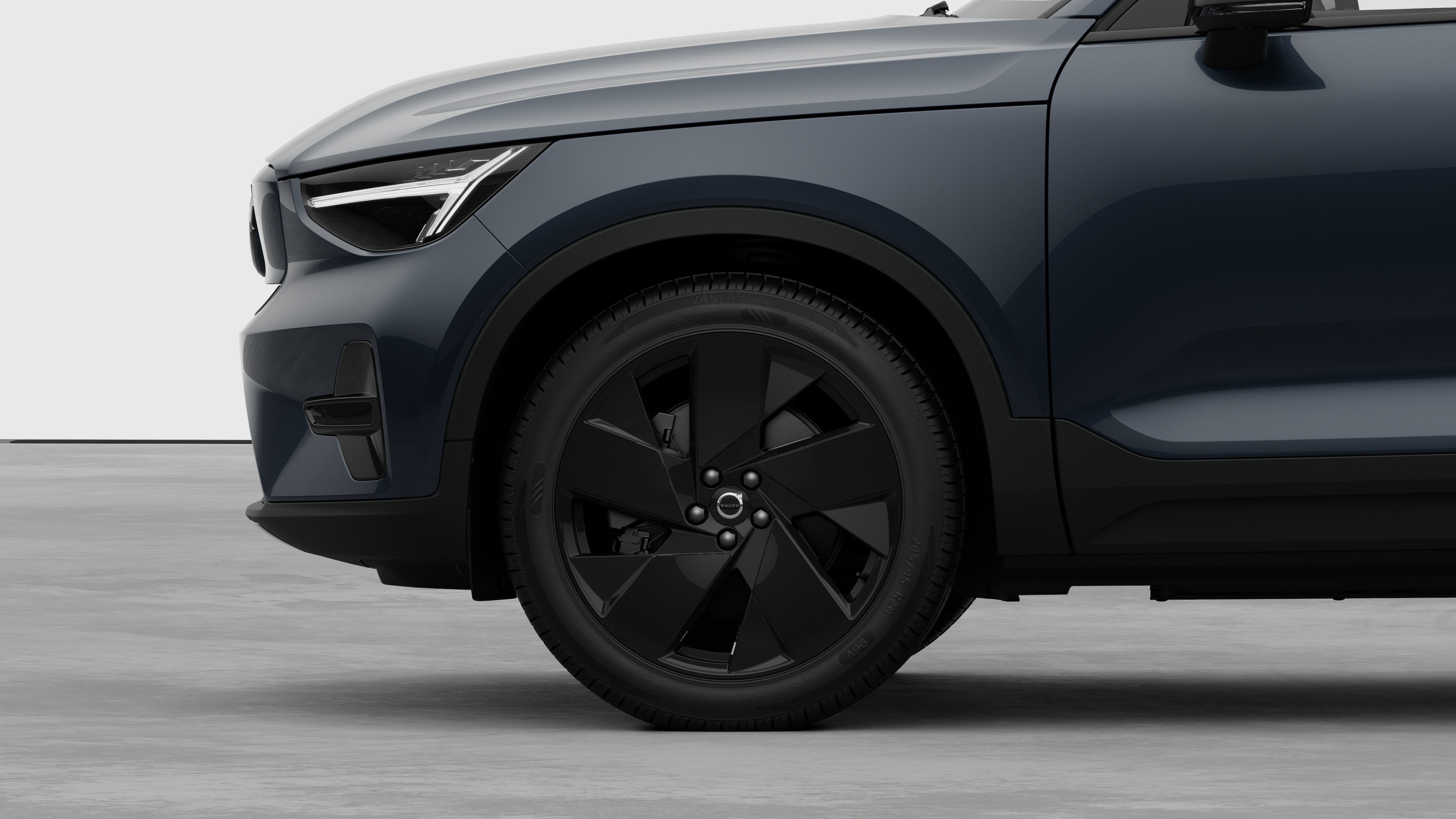 Seitenansicht eines Volvo Fahrzeugs mit Fokus auf Vorderrad und Kotflügel vor einem schlichten Studiohintergrund.