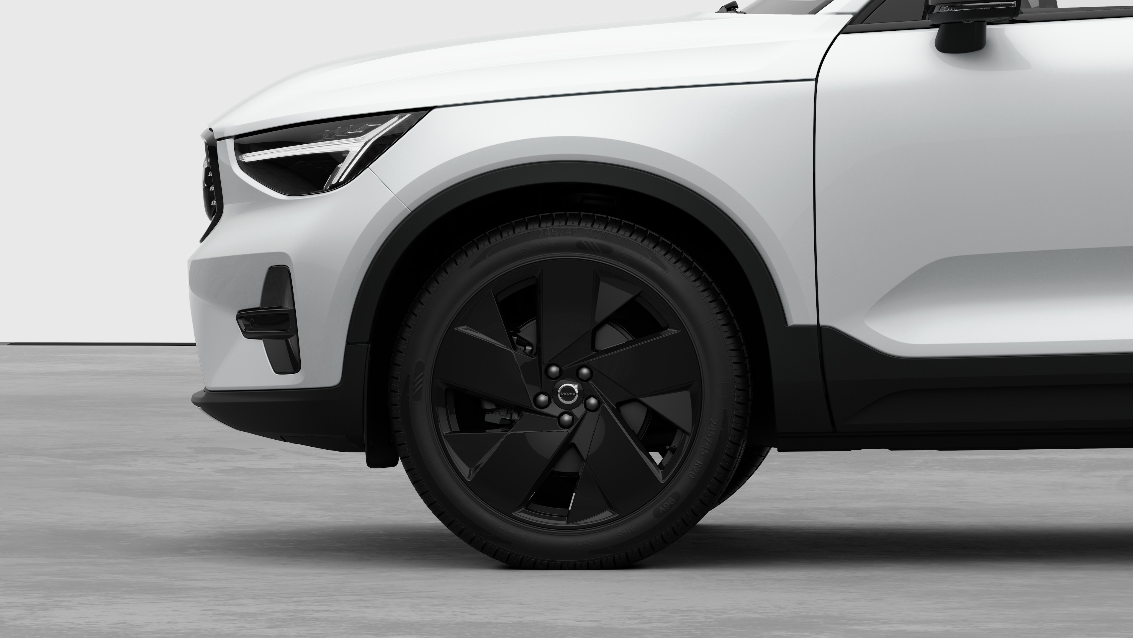 Seitenansicht eines Volvo Fahrzeugs mit Fokus auf Vorderrad und Kotflügel vor einem schlichten Studiohintergrund.
