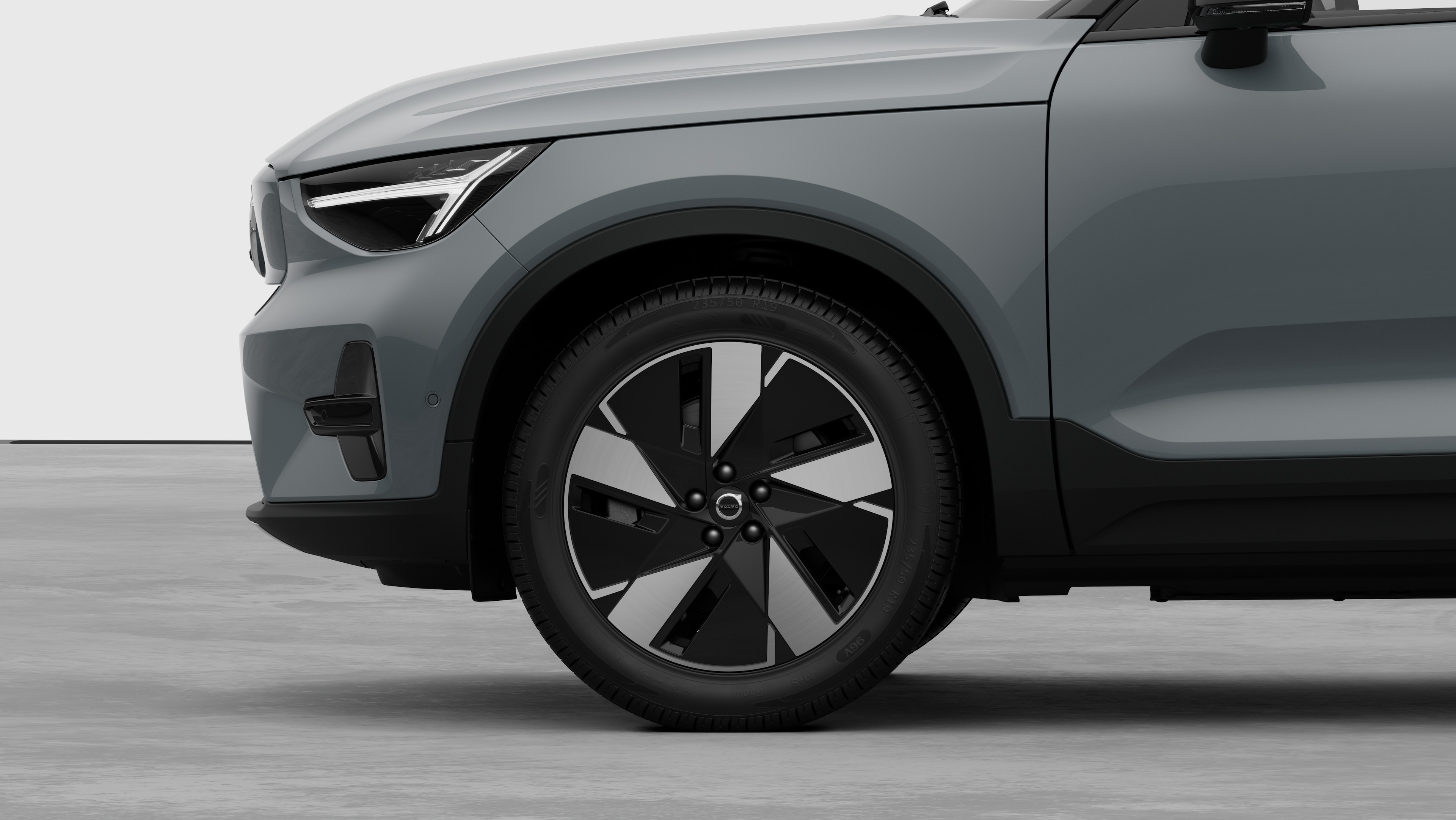 Vue latérale extérieure de la Volvo se concentrant sur la roue avant et l’aile, sur un fond de studio uni.