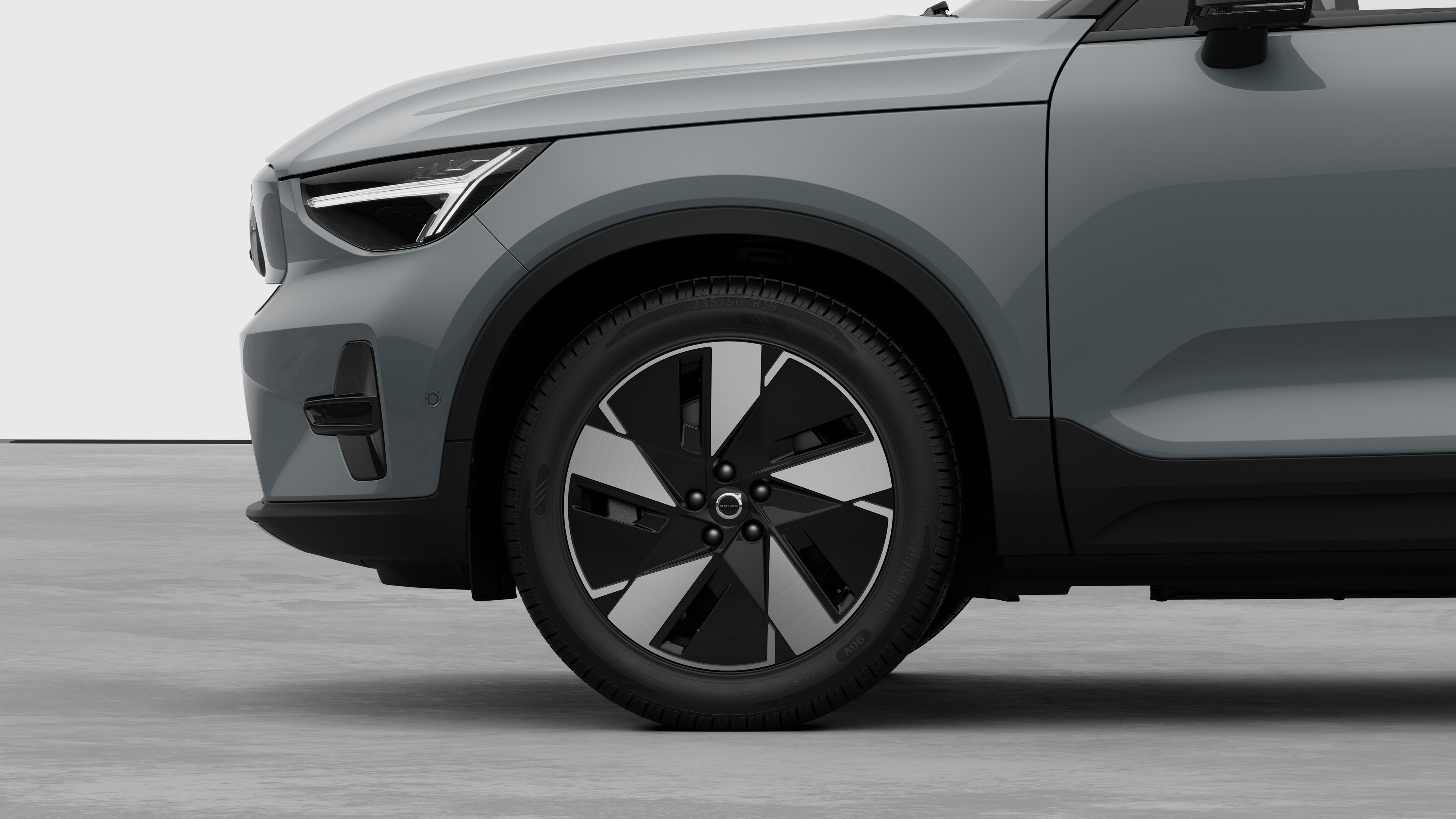 Vue latérale extérieure de la Volvo se concentrant sur la roue avant et l’aile, sur un fond de studio uni.