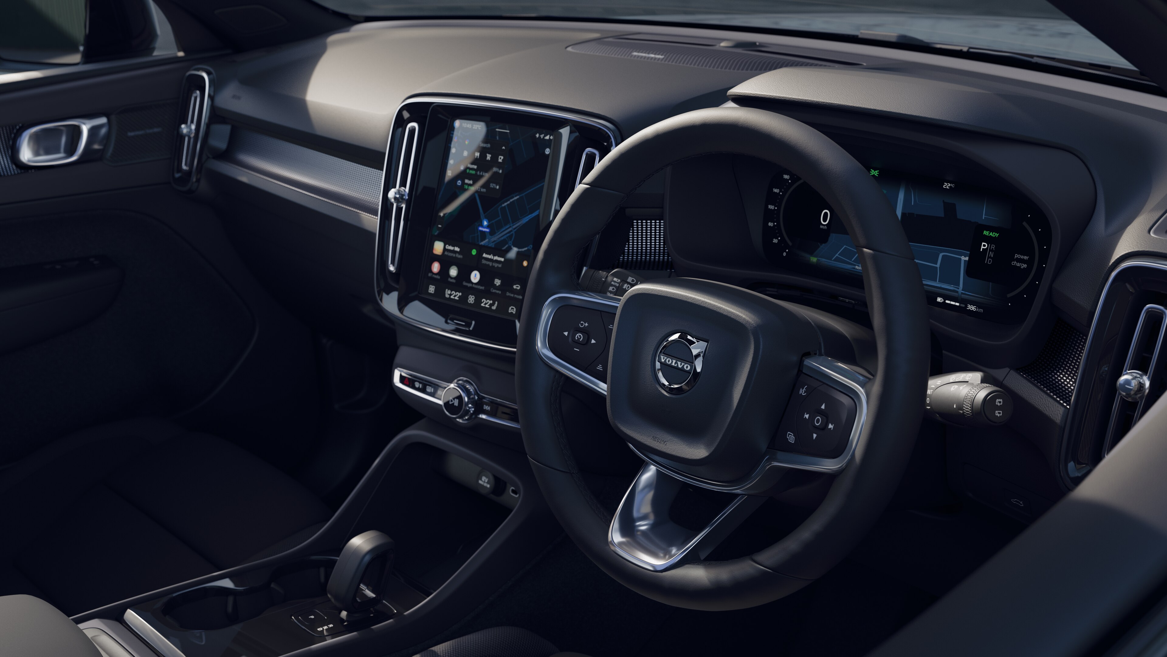 Volvo car interior showing dashboard, steering wheel, and center console with digital display in an open road background.