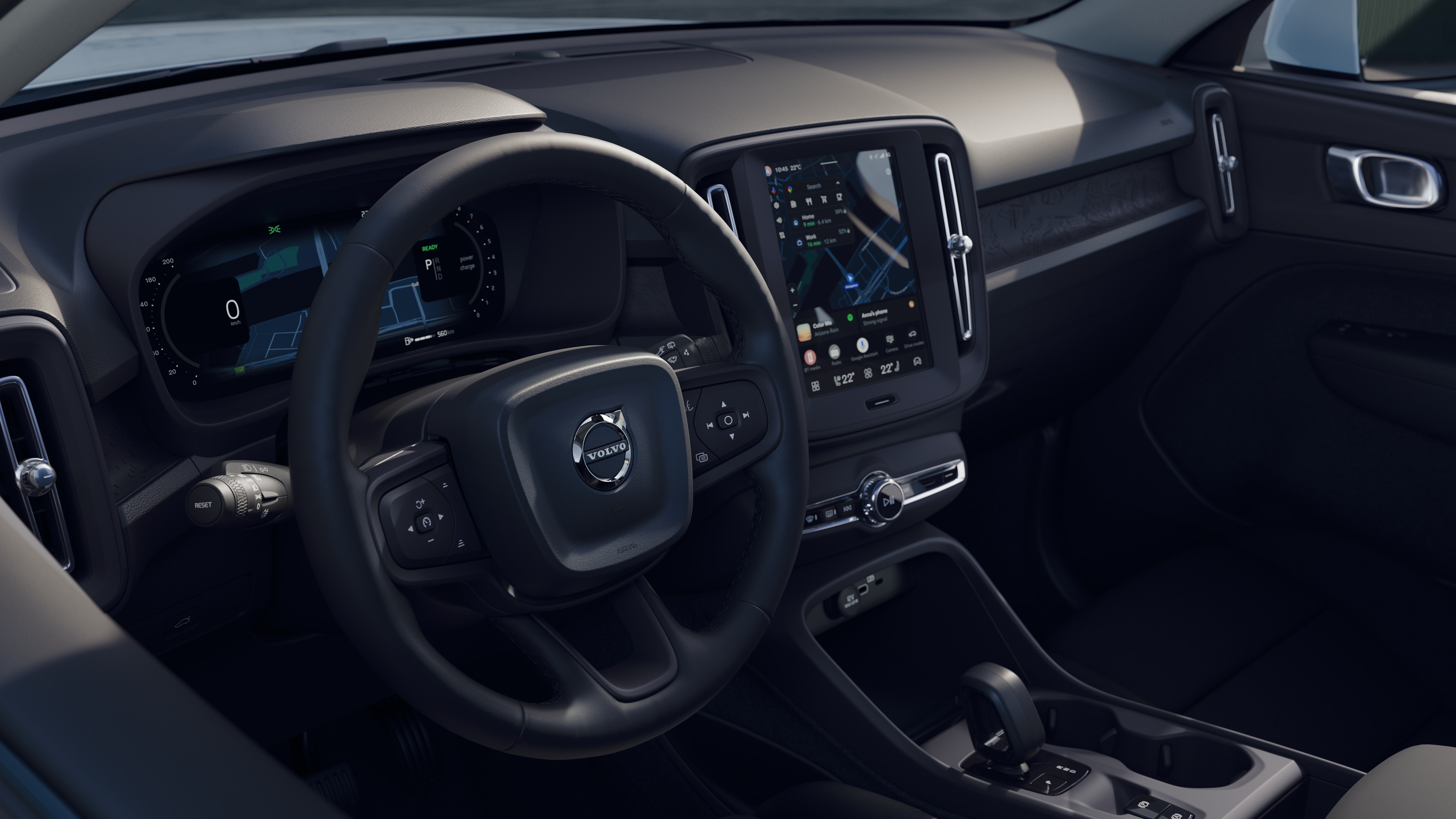 Innenraum eines Volvo mit Armaturenbrett, Lenkrad und Mittelkonsole mit Digitalanzeige vor dem Hintergrund der offenen Straße.