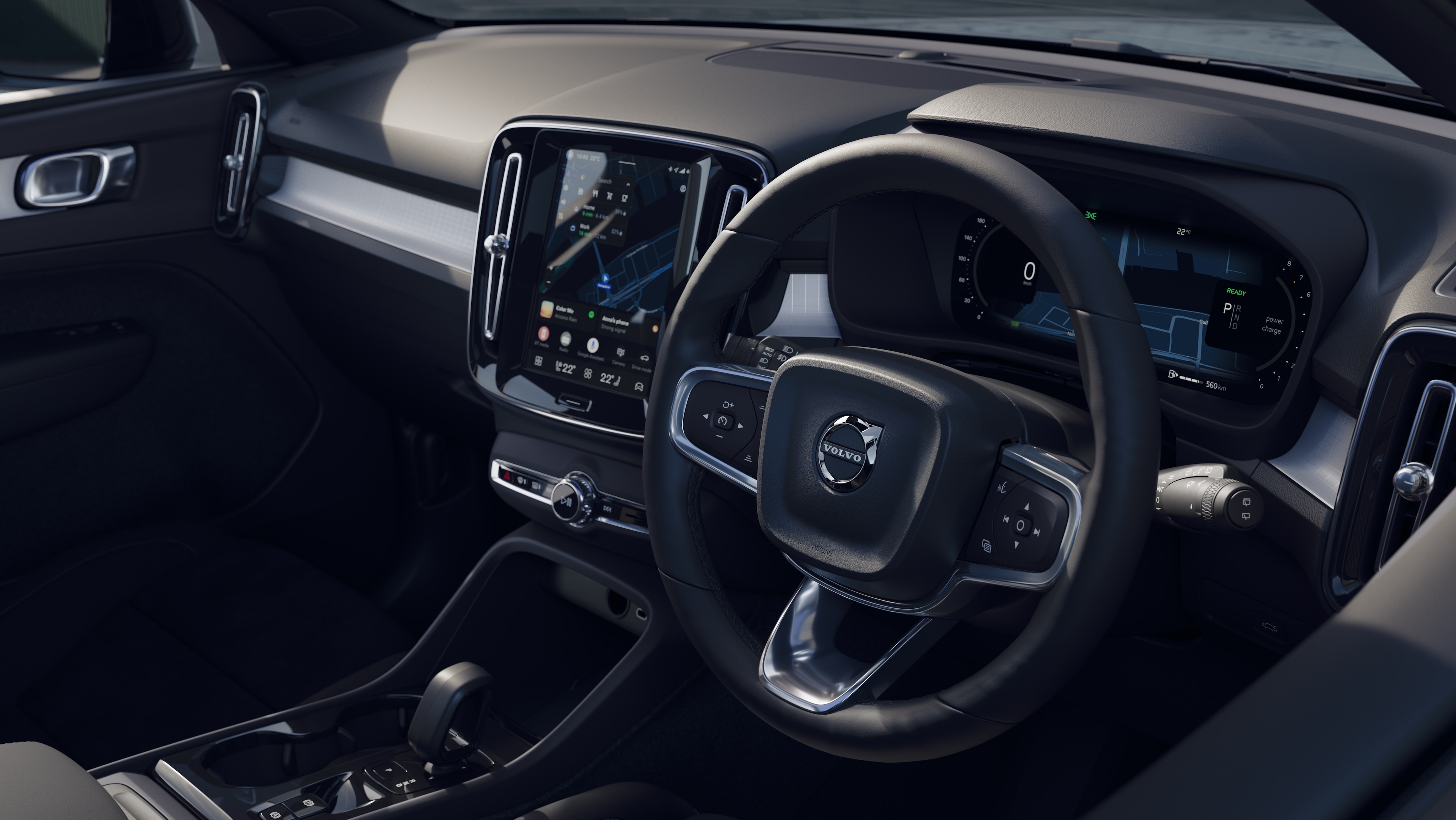 Volvo car interior showing dashboard, steering wheel, and center console with digital display in an open road background.