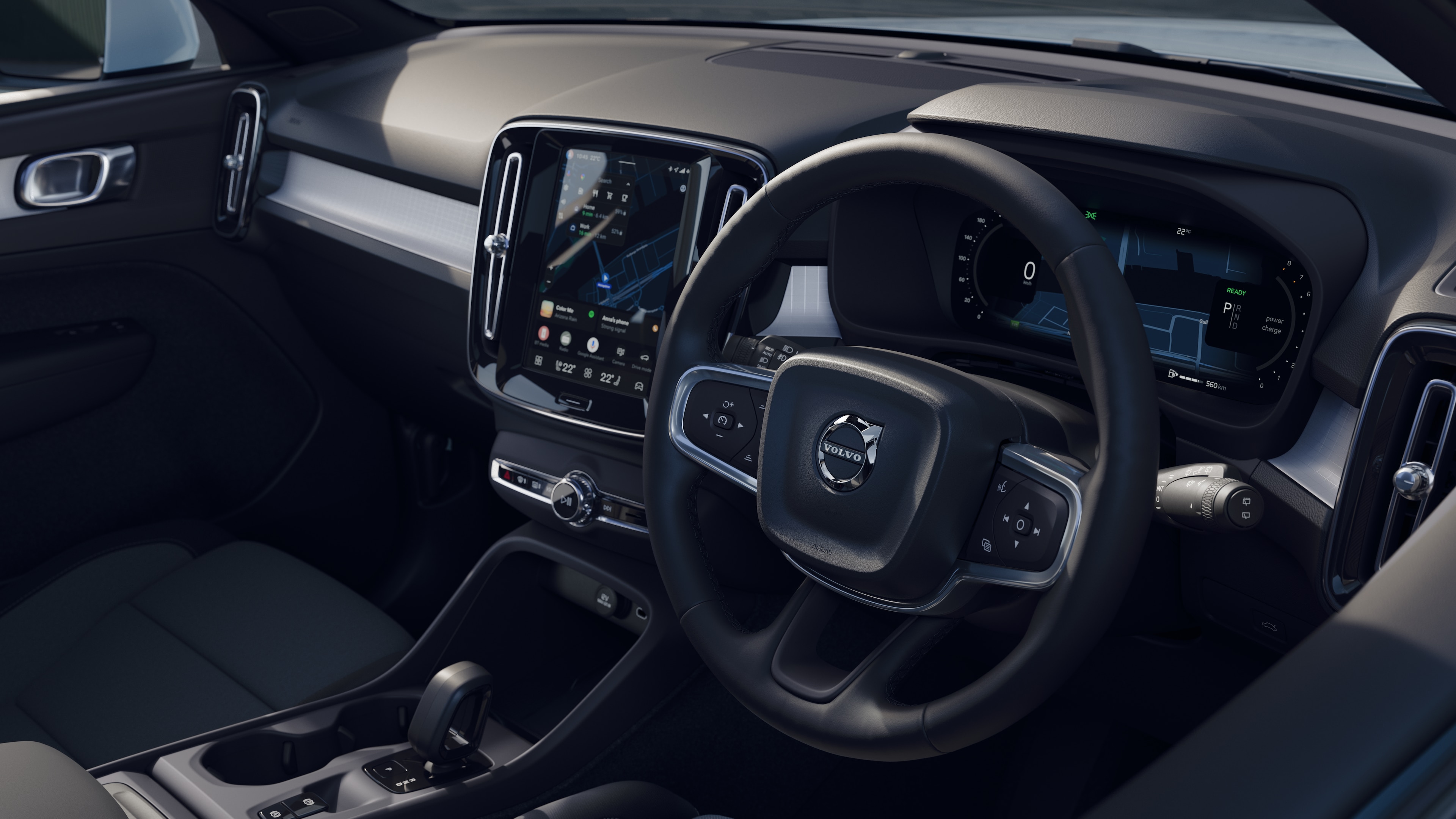 Volvo car interior showing dashboard, steering wheel, and center console with digital display in an open road background.