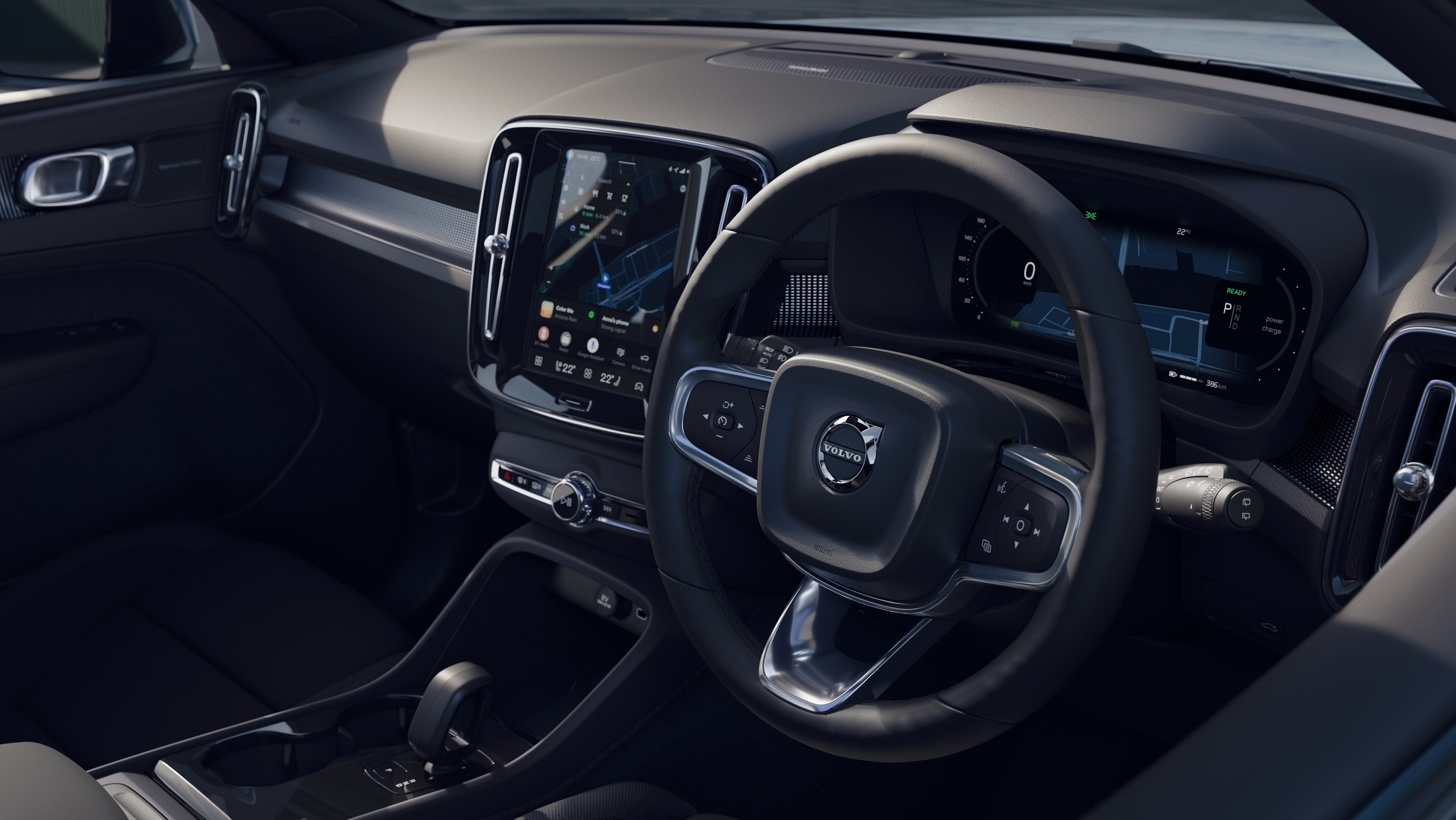 Volvo car interior showing dashboard, steering wheel, and center console with digital display in an open road background.