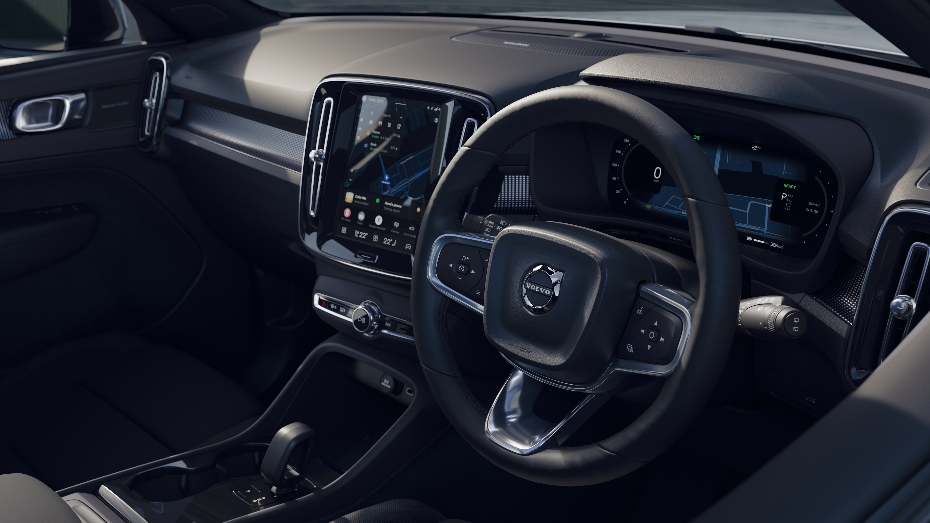Volvo car interior showing dashboard, steering wheel, and center console with digital display in an open road background.