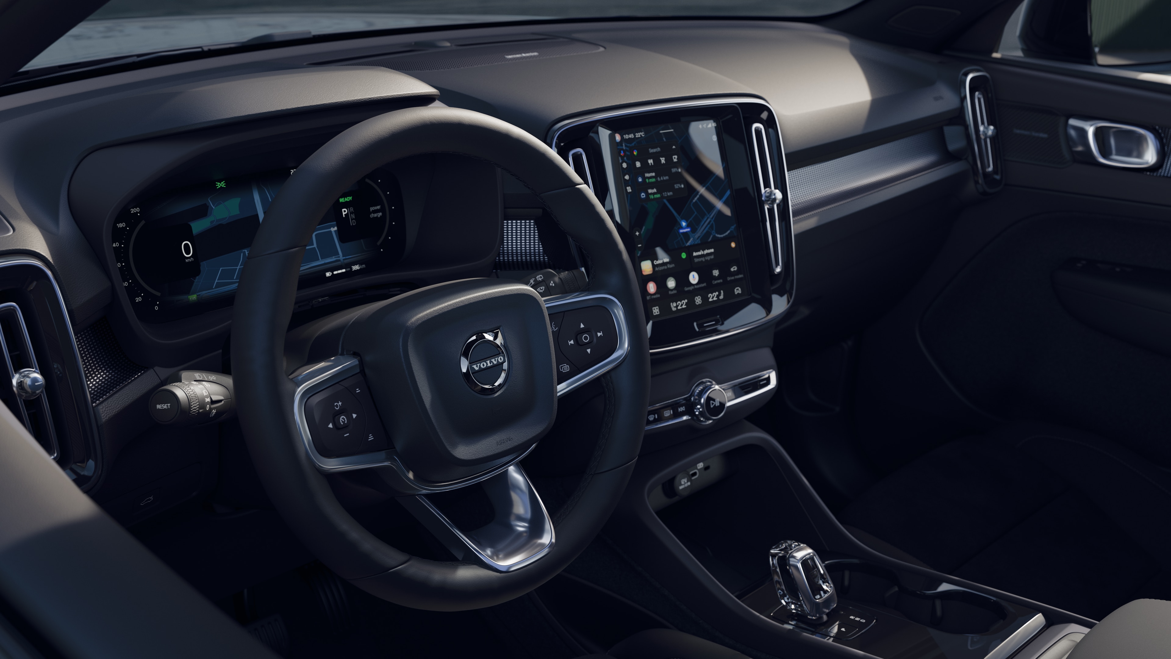 Volvo car interior showing dashboard, steering wheel, and center console with digital display in an open road background.
