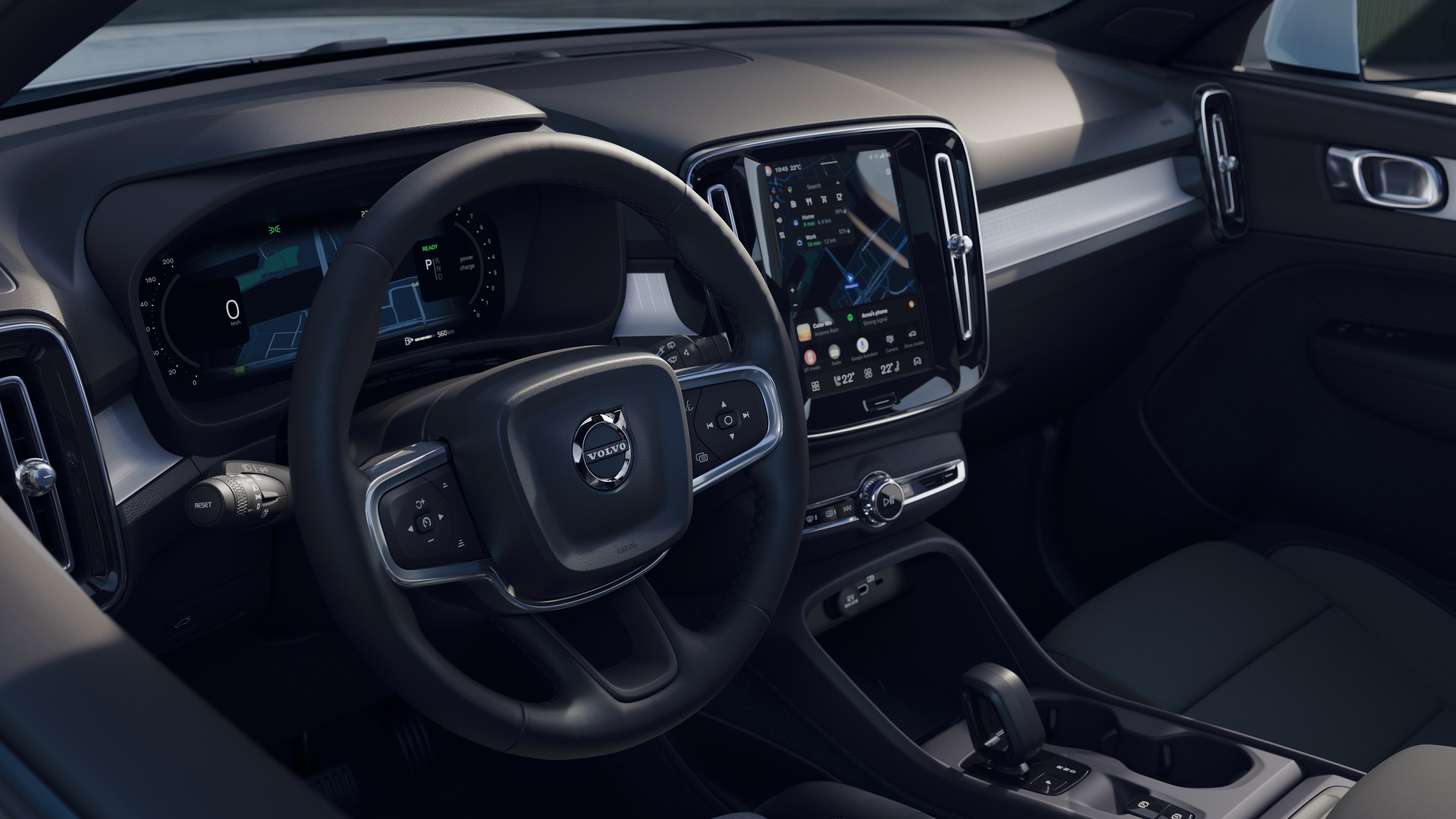 Το εσωτερικό ενός αυτοκινήτου Volvo όπου φαίνονται το ταμπλό, το τιμόνι και η κεντρική κονσόλα, με ψηφιακή οθόνη σε φόντο ανοιχτό δρόμο.