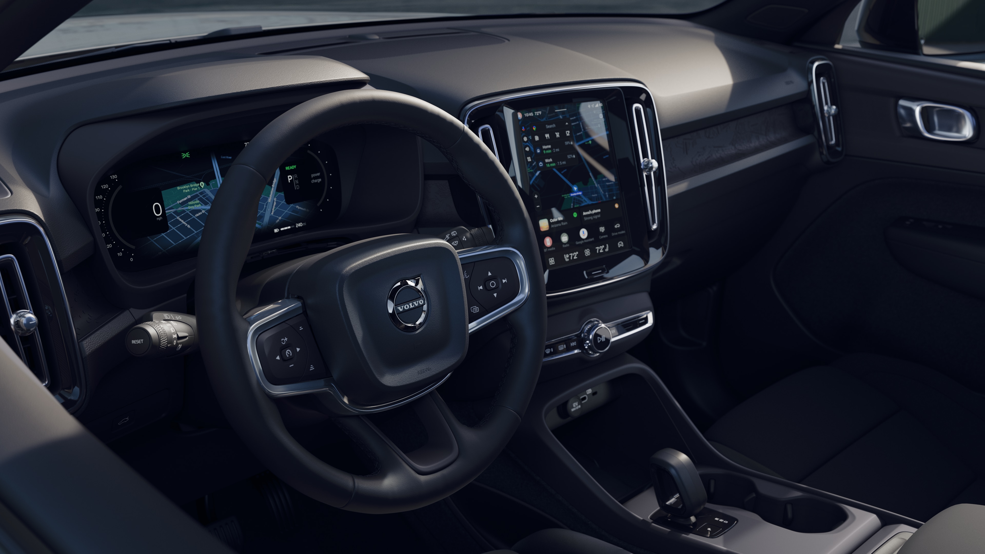 Interior del vehículo Volvo que muestra el salpicadero, el volante y la consola central con pantalla digital en un fondo de carretera abierta.
