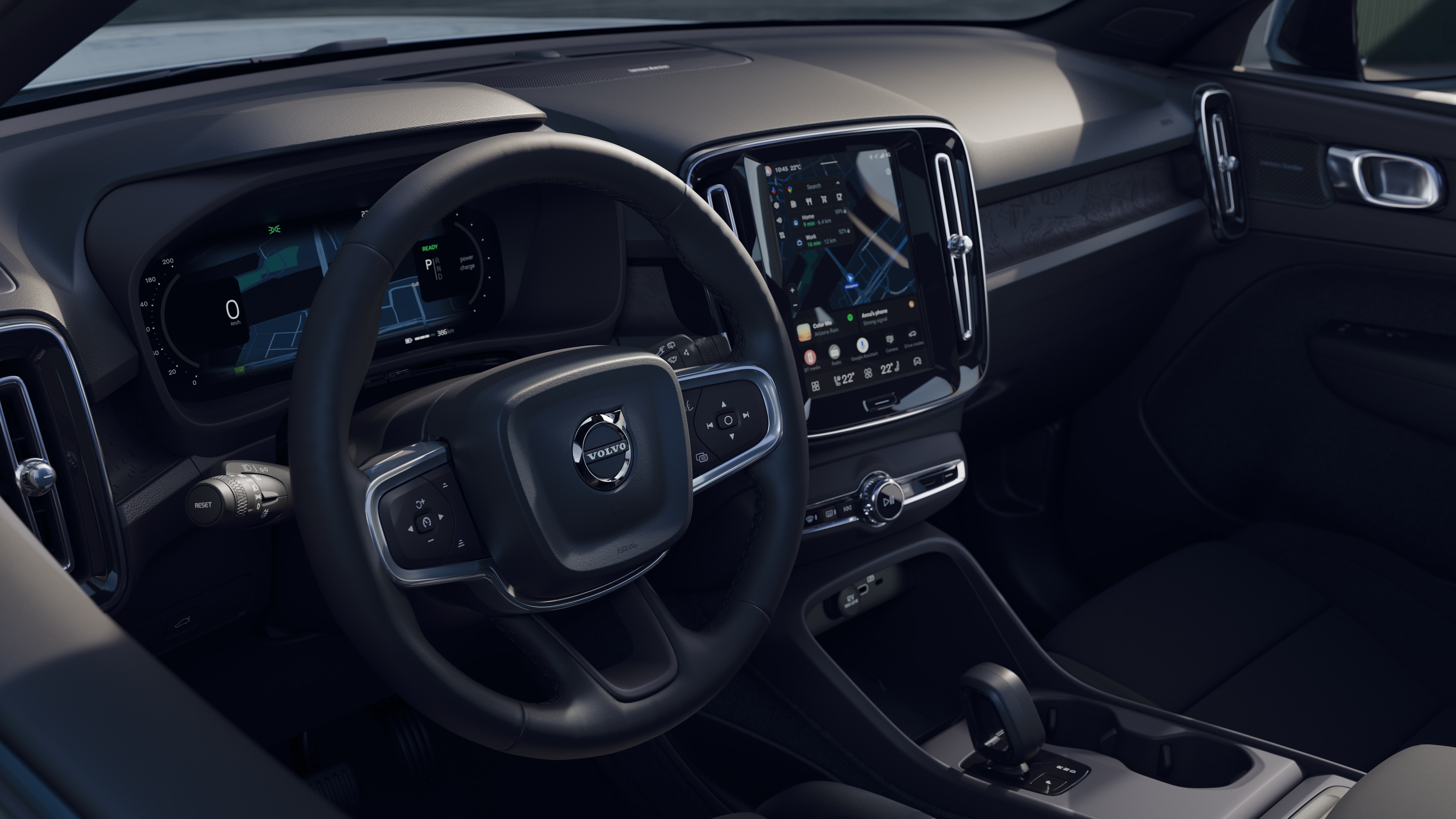 Интериор на автомобил Volvo, показващ арматурното табло, волана и централната конзола с цифров дисплей на открит пътен фон.