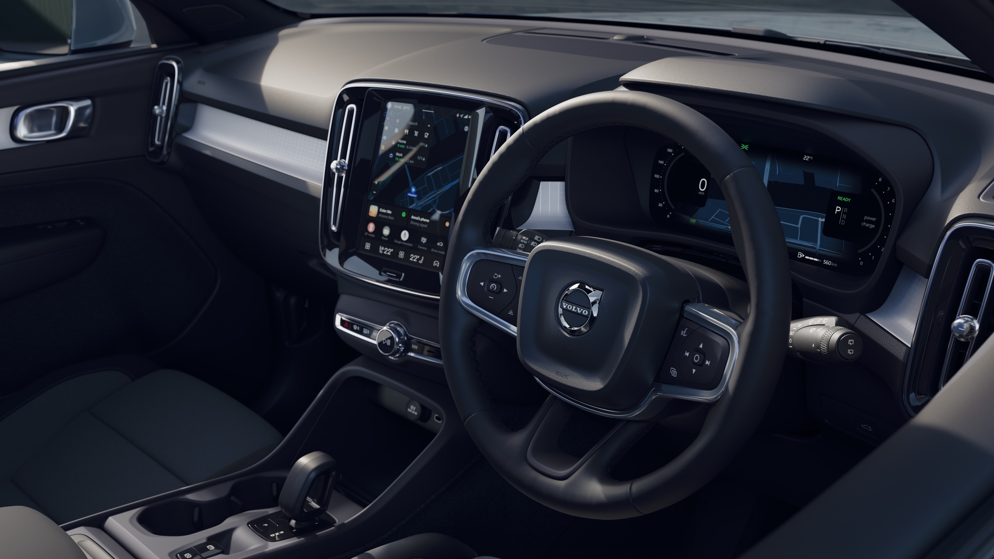 Volvo car interior showing dashboard, steering wheel, and center console with digital display in an open road background.