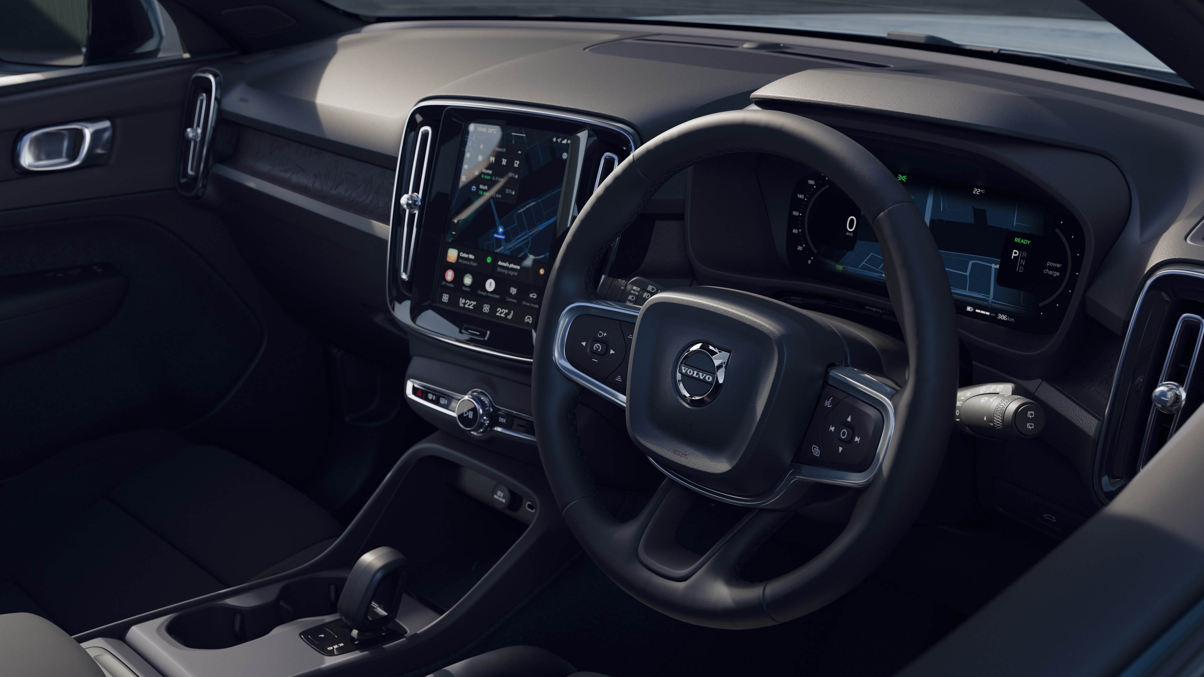 Volvo car interior showing dashboard, steering wheel, and center console with digital display in an open road background.