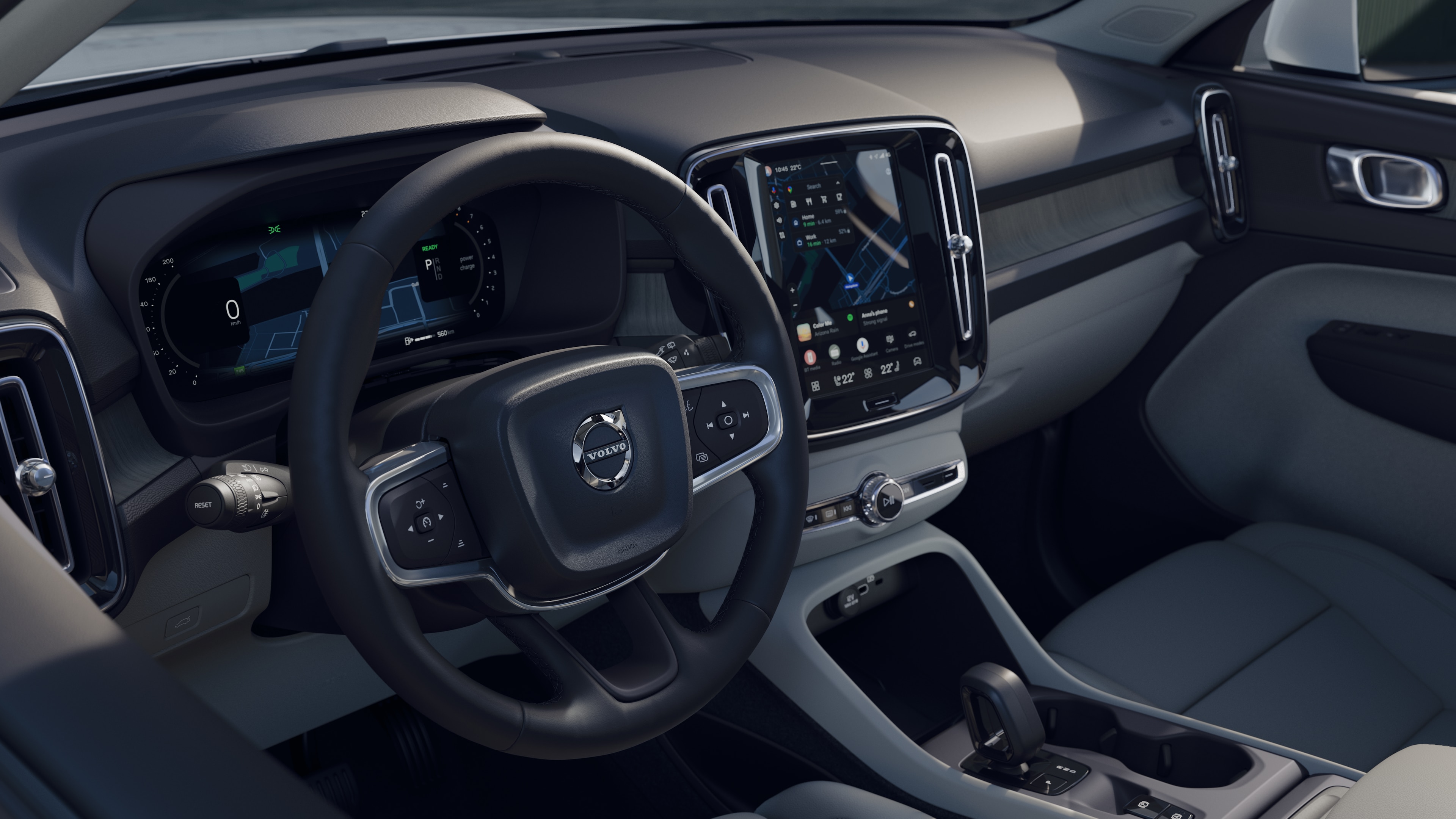 열린 도로 배경에 디지털 디스플레이가 있는 대시보드, 스티어링 휠 및 센터 콘솔을 보여주는 볼보 자동차 내부.