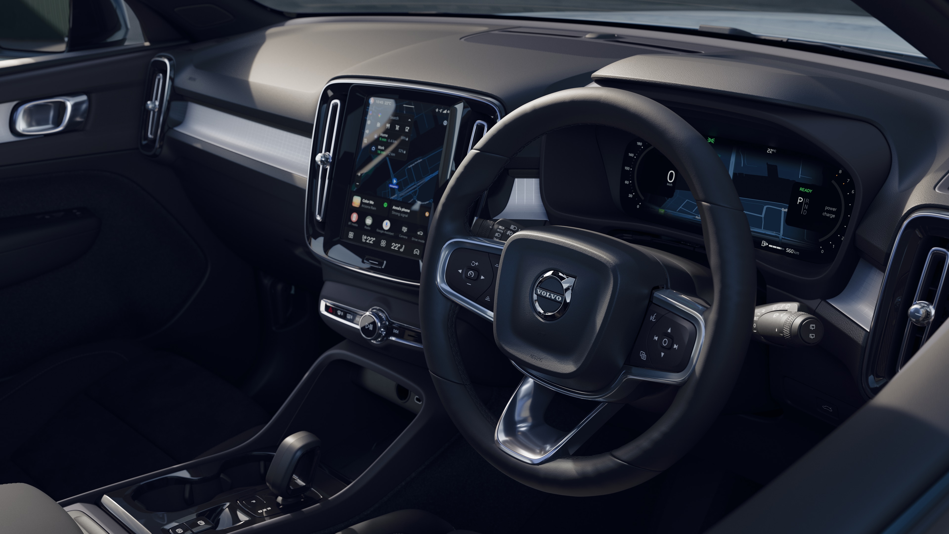 Volvo car interior showing dashboard, steering wheel, and center console with digital display in an open road background.