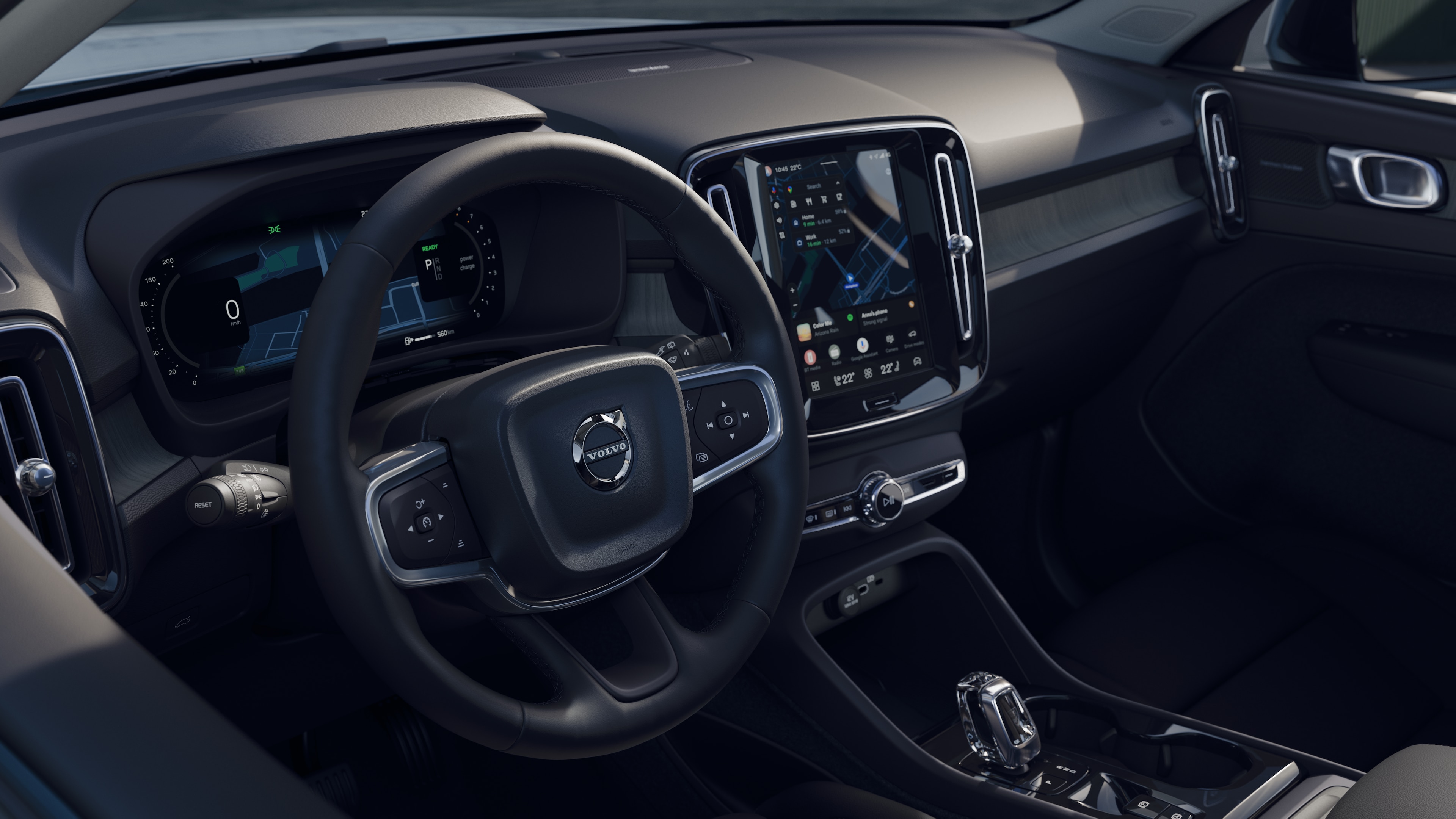 תא הנוסעים של מכונית וולוו מציג את לוח המחוונים, גלגל ההגה והקונסולה המרכזית עם תצוגה דיגיטלית על רקע כביש פתוח.