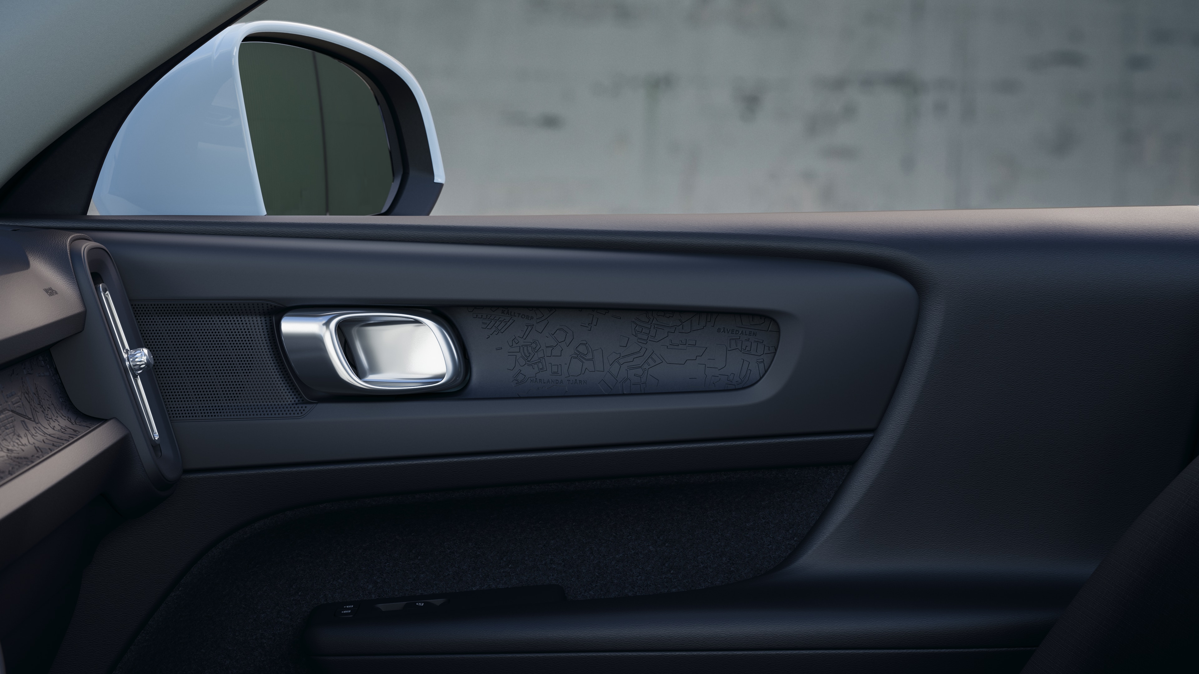 Innenraum eines Volvo mit Beifahrer- und Rücksitzen, Lenkrad, Armaturenbrett und Mittelkonsole vor einem schlichten Studiohintergrund.