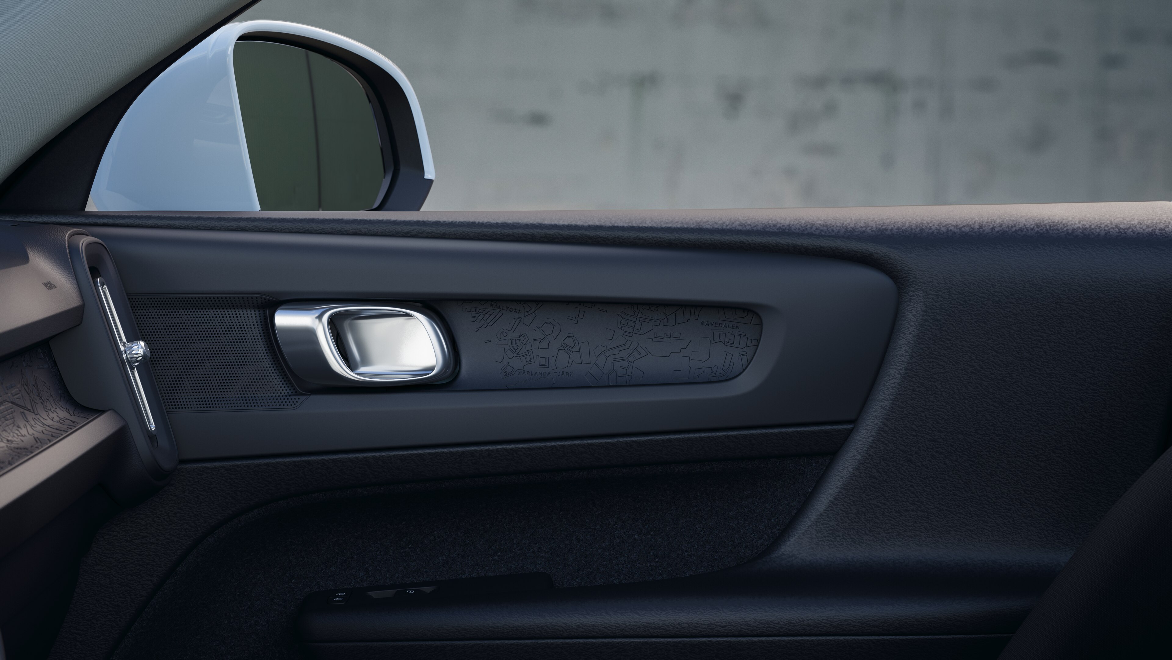 Innenraum eines Volvo mit Beifahrer- und Rücksitzen, Lenkrad, Armaturenbrett und Mittelkonsole vor einem schlichten Studiohintergrund.