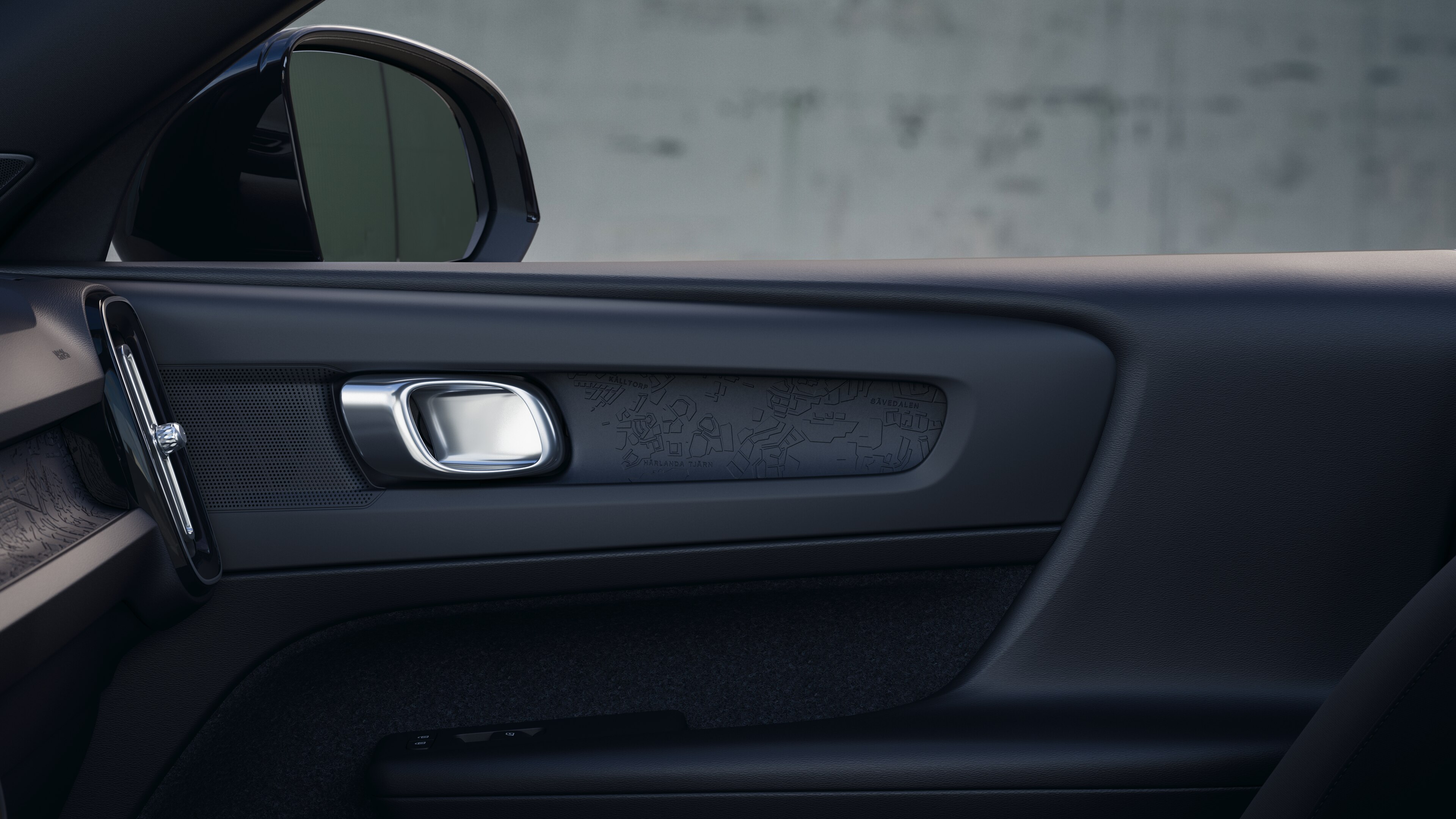 Het interieur van de Volvo met de passagiersstoelen voor- en achterin, het stuur, het dashboard en de middenconsole tegen een effen studioachtergrond.