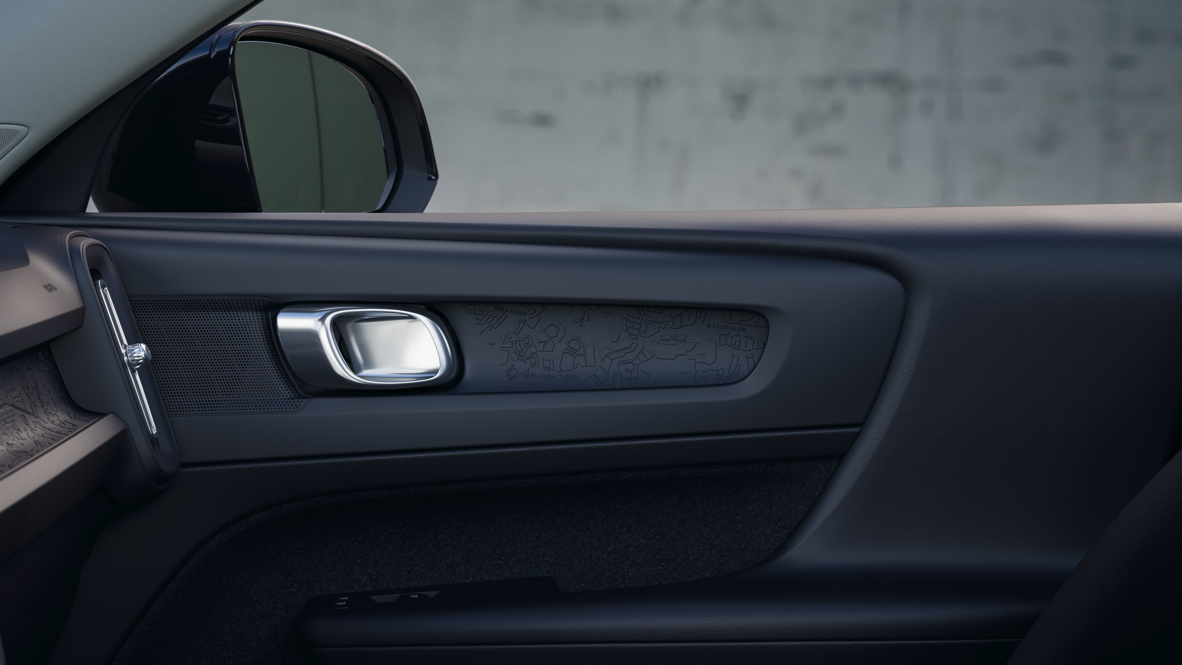 Het interieur van de Volvo met de passagiersstoelen voor- en achterin, het stuur, het dashboard en de middenconsole tegen een effen studioachtergrond.