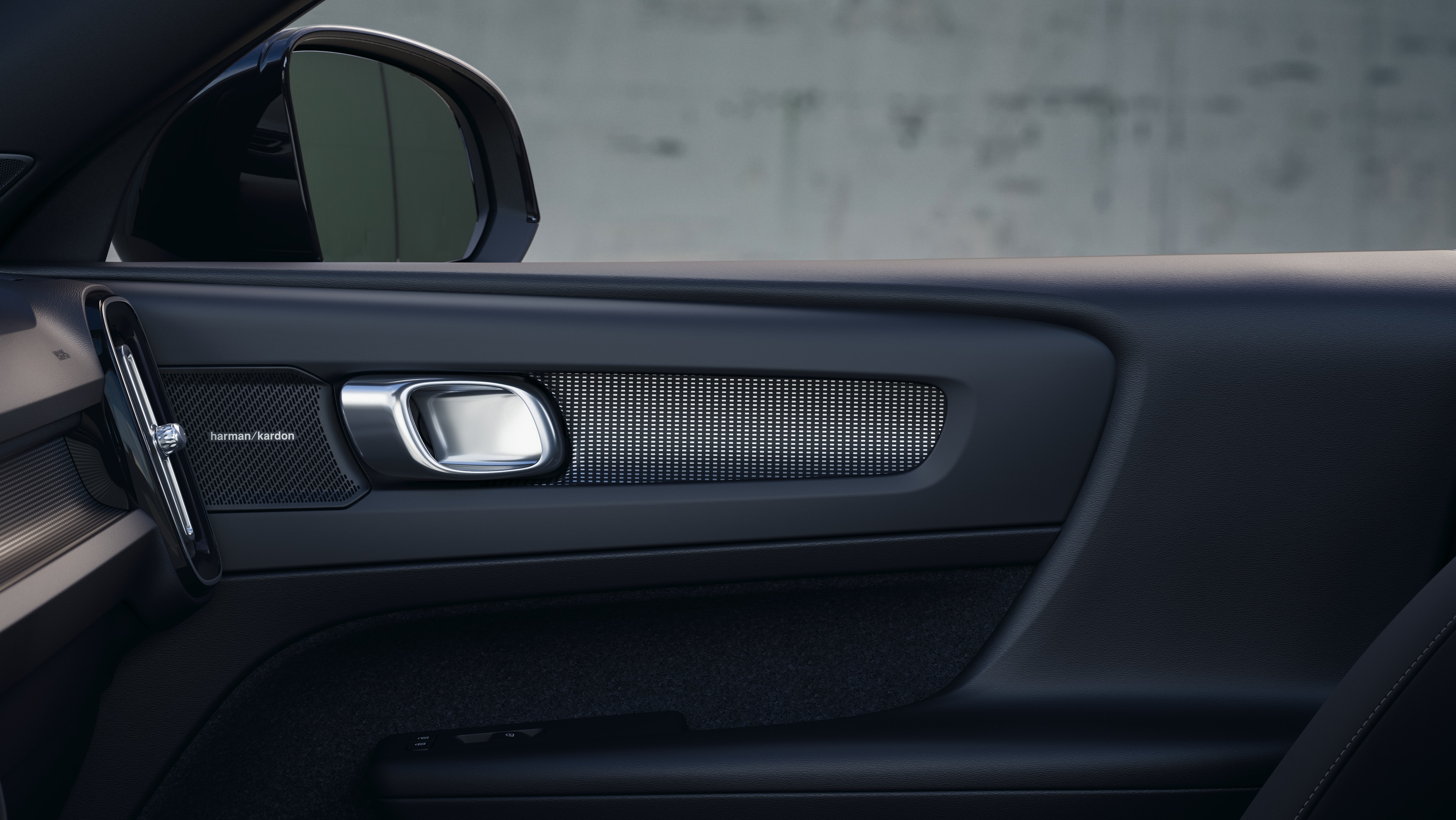 Het interieur van de Volvo met de passagiersstoelen voor- en achterin, het stuur, het dashboard en de middenconsole tegen een effen studioachtergrond.