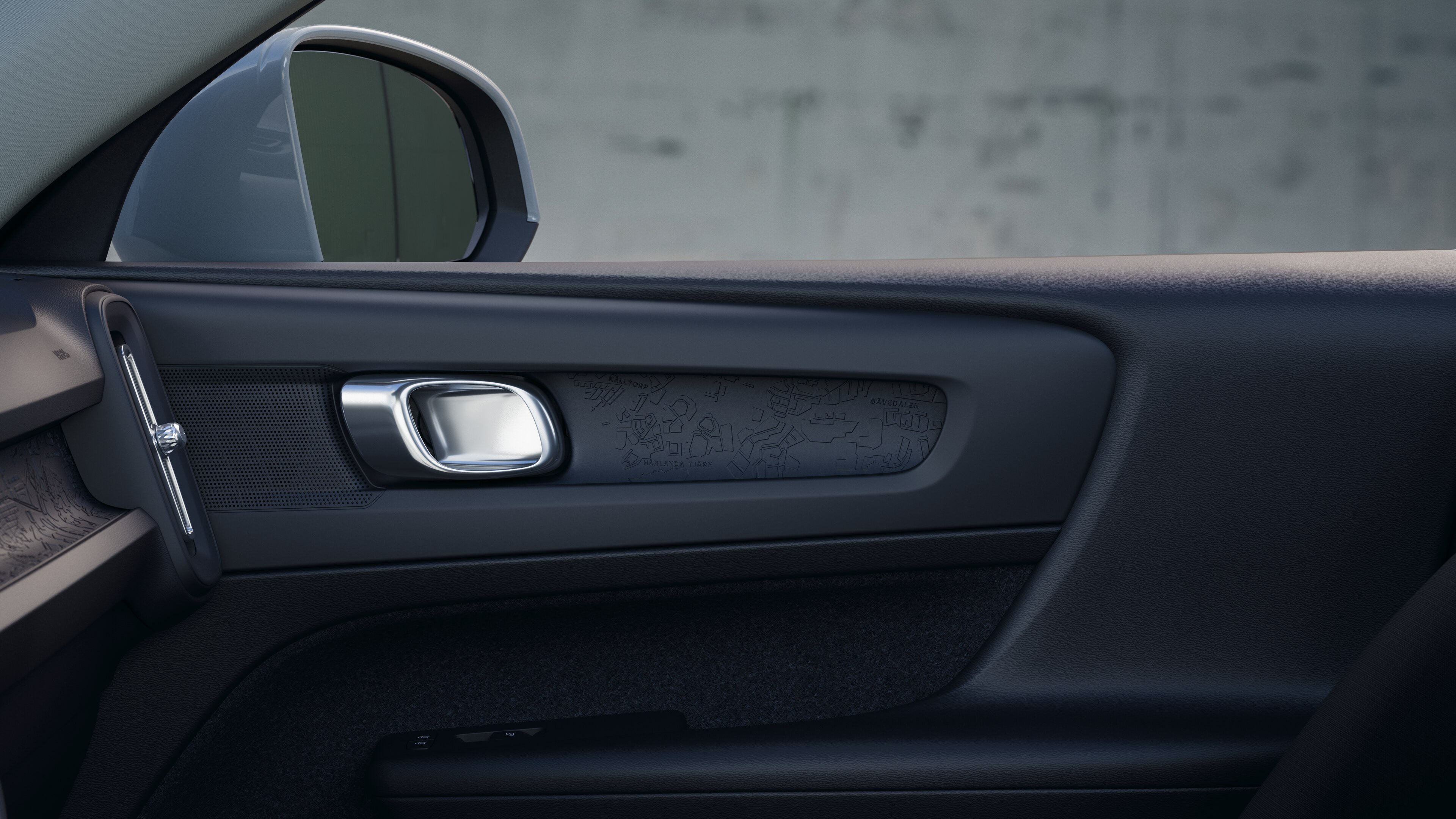 Het interieur van de Volvo met de passagiersstoelen voor- en achterin, het stuur, het dashboard en de middenconsole tegen een effen studioachtergrond.