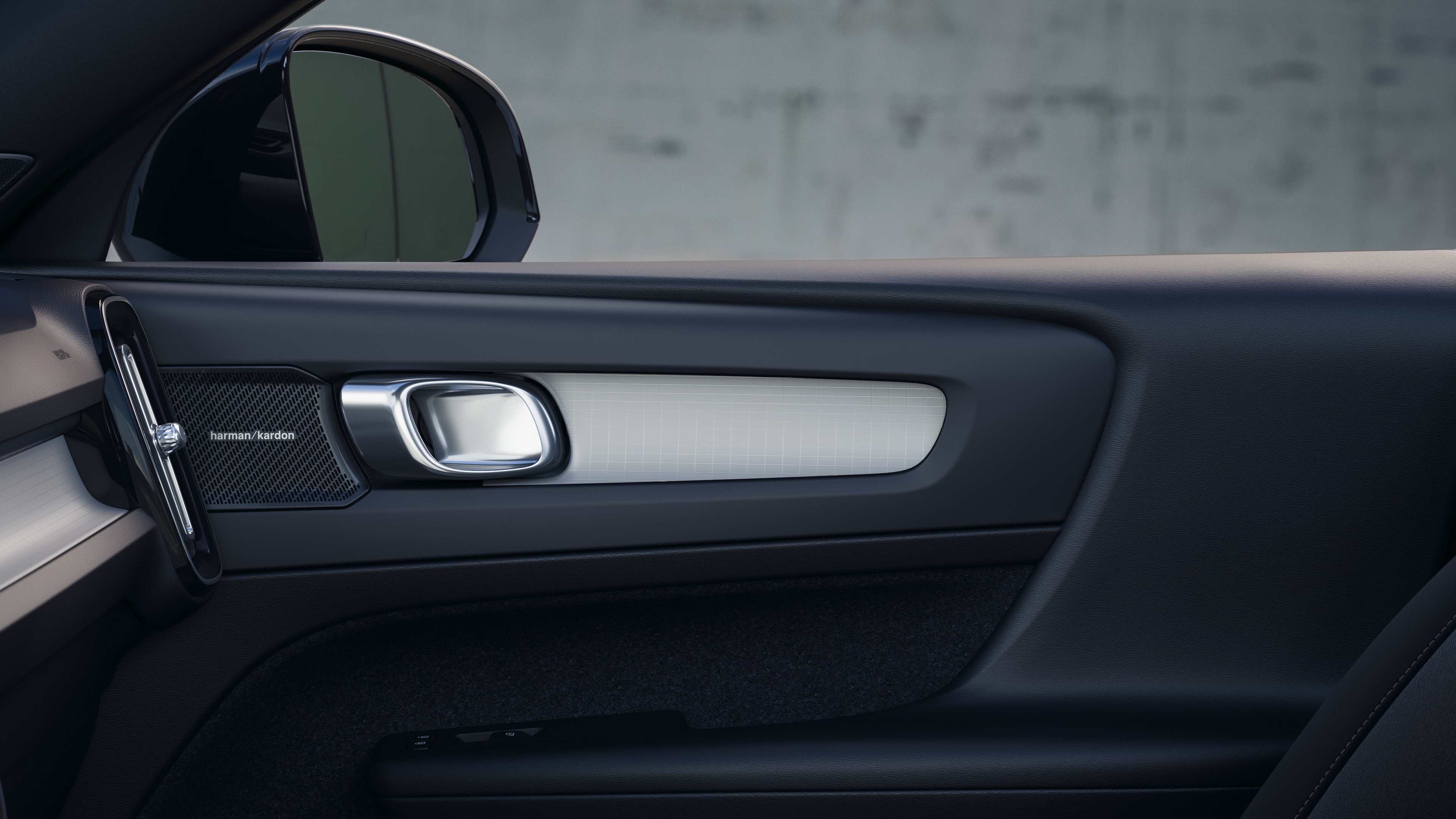 Volvo automašīnas salons ar priekšējiem un aizmugurējiem pasažieru sēdekļiem, stūri, instrumentu paneli un centrālo konsoli uz vienkārša studijas fona.